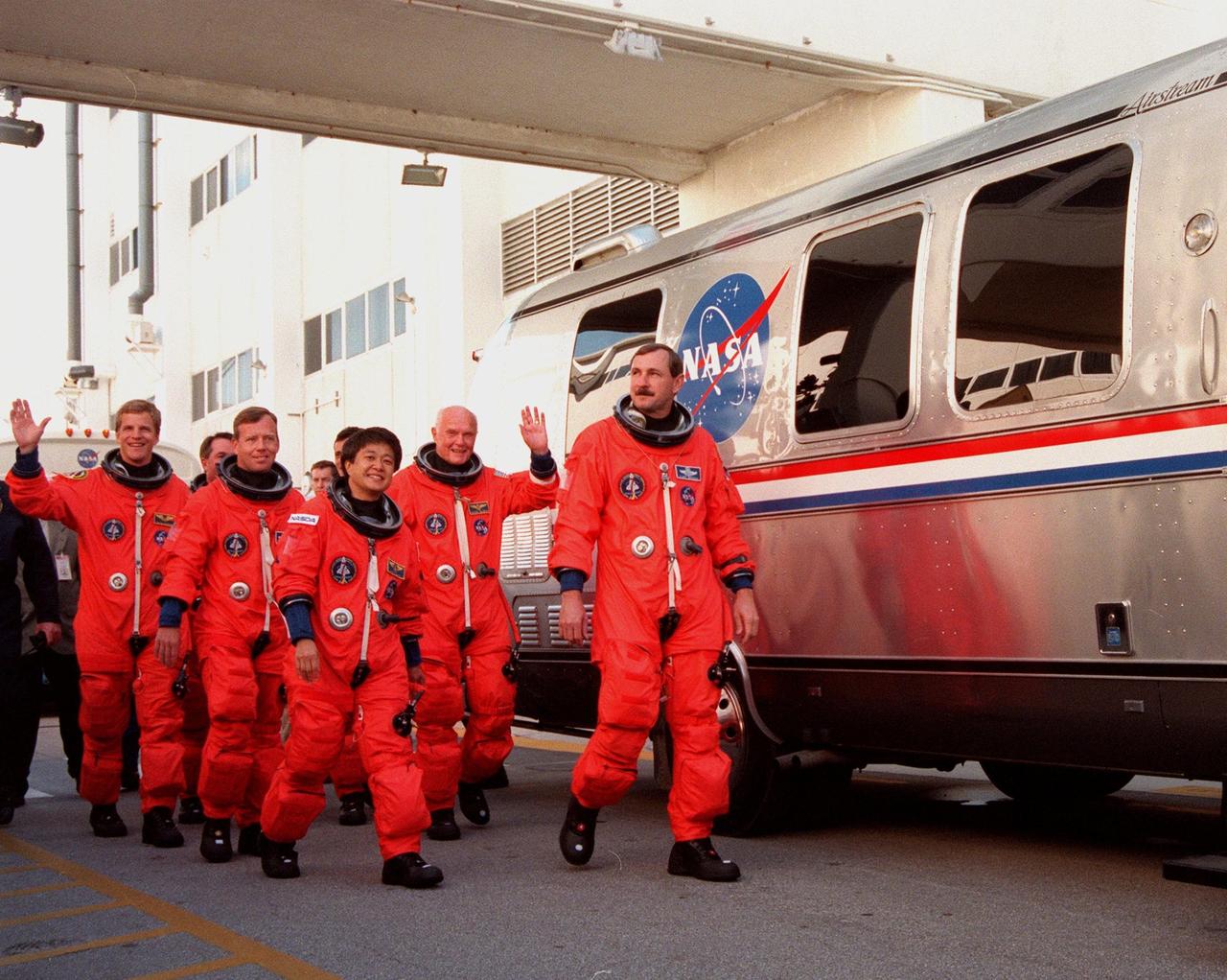 After leaving the Operations and Checkout Building, the STS-95 crew wave at well-wishers as they approach the Astrovan they will board for their trip to Launch Pad 39B. Leading the group is Mission Commander Curtis L. Brown Jr. (far right); Other crew members are (left to right) Mission Specialists Scott E. Parazynski , Stephen K. Robinson, Pilot Steven W. Lindsey, Mission Specialist Pedro Duque of Spain (hidden), with the European Space Agency (ESA), Payload Specialist Chiaki Mukai, with the National Space Development Agency of Japan (NASDA), and Payload Specialist John H. Glenn Jr. Targeted for launch at 2 p.m. EST on Oct. 29, the mission is expected to last 8 days, 21 hours and 49 minutes, and return to KSC at 11:49 a.m. EST on Nov. 7. The STS-95 mission includes research payloads such as the Spartan solar-observing deployable spacecraft, the Hubble Space Telescope Orbital Systems Test Platform, the International Extreme Ultraviolet Hitchhiker, as well as the SPACEHAB single module with experiments on space flight and the aging process