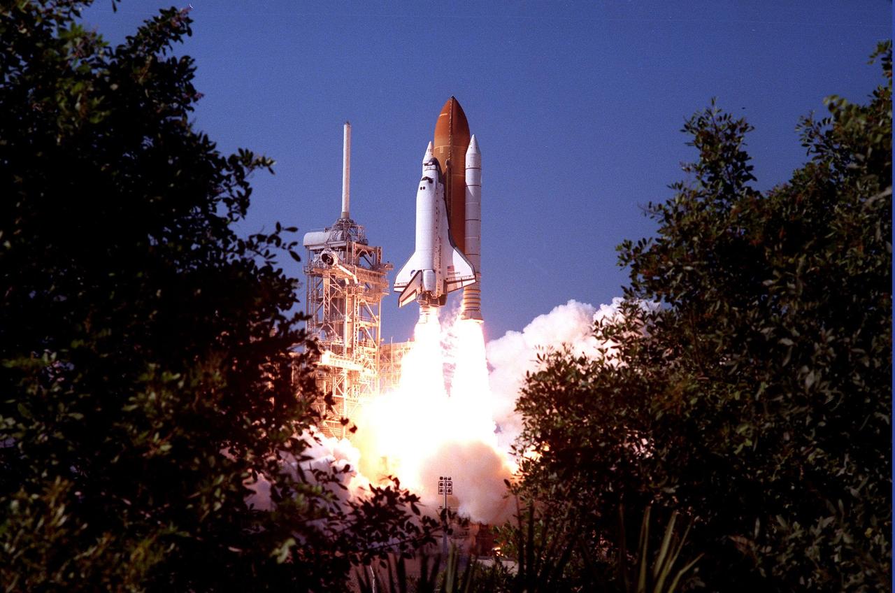 Framed by the foliage of the Canaveral National Sea Shore, Space Shuttle Discovery soars through bright blue skies as it lifts off from Launch Pad 39B at 2:19 p.m. EST Oct. 29 on mission STS-95. Making his second voyage into space after 36 years is Payload Specialist John H. Glenn Jr., senator from Ohio. Other crew members are Mission Commander Curtis L. Brown Jr., Pilot Steven W. Lindsey, Payload Specialist Chiaki Mukai, (M.D., Ph.D.), with the National agency for Space Development (NASDA), Mission Specialist Stephen K. Robinson, Mission Specialist Pedro Duque of Spain, representing the European Space Agency (ESA), and Mission Specialist Scott E. Parazynski. The STS-95 mission includes research payloads such as the Spartan solar-observing deployable spacecraft, the Hubble Space Telescope Orbital Systems Test Platform, the International Extreme Ultraviolet Hitchhiker, as well as the SPACEHAB single module with experiments on space flight and the aging process. Discovery is expected to return to KSC at 11:49 a.m. EST on Nov. 7