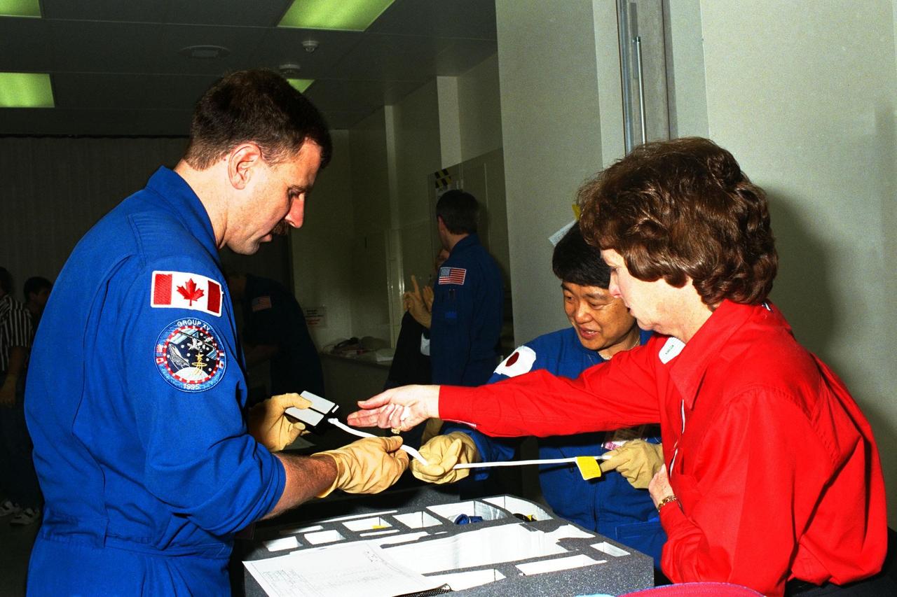 STS-90 Mission Specialist Dafydd "Dave" Rhys Williams, M.D., with the Canadian Space Agency, and back-up Payload Specialist Chiaki Mukai, M.D., Ph.D., with the National Space Development Agency of Japan, examine items to be used during the Crew Equipment Interface Test (CEIT) in Kennedy Space Center's (KSC's) Operations and Checkout Building, where the Neurolab payload is undergoing processing. The CEIT gives astronauts an opportunity to get a hands-on look at the payloads with which they will be working on-orbit. STS-90 is scheduled to launch aboard the Shuttle Columbia from KSC on April 2. Investigations during the Neurolab mission will focus on the effects of microgravity on the nervous system. Specifically, experiments will study the adaptation of the vestibular system, the central nervous system, and the pathways that control the ability to sense location in the absence of gravity, as well as the effect of microgravity on a developing nervous system