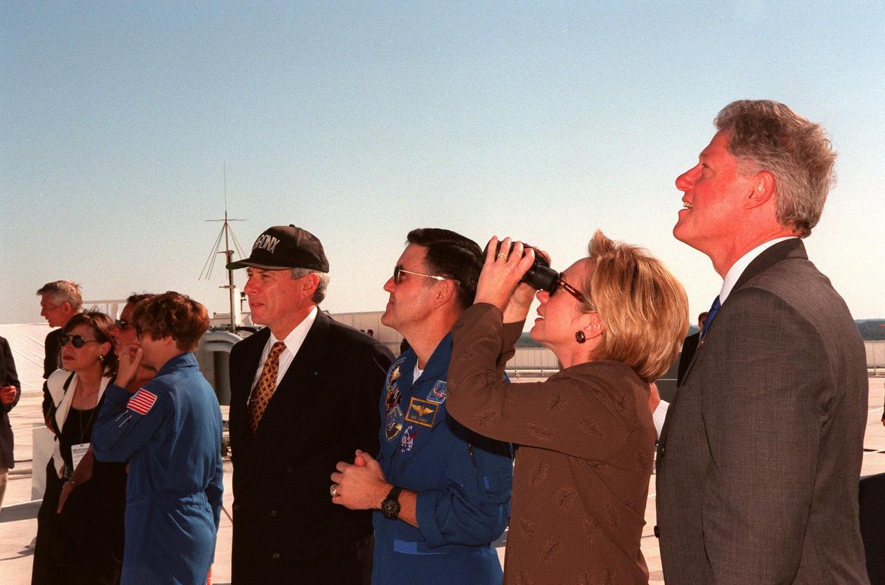 Watching a successful launch of Space Shuttle Discovery from the roof of the Launch Control Center are (left to right) Astronaut Eileen Collins (in flight suit) with unidentified companions, NASA Administrator Daniel Goldin, Astronaut Robert Cabana, First Lady Hillary Rodham Clinton, and U.S. President Bill Clinton. This was the first launch of a Space Shuttle to be viewed by President Clinton, or any President to date. They attended the launch to witness the return to space of American legend John H. Glenn Jr., payload specialist on mission STS-95. Collins will command the crew of STS-93, the first woman to hold that position. Cabana will command the crew of STS-88, the first Space Shuttle mission to carry hardware to space for the assembly of the International Space Station, targeted for liftoff on Dec. 3