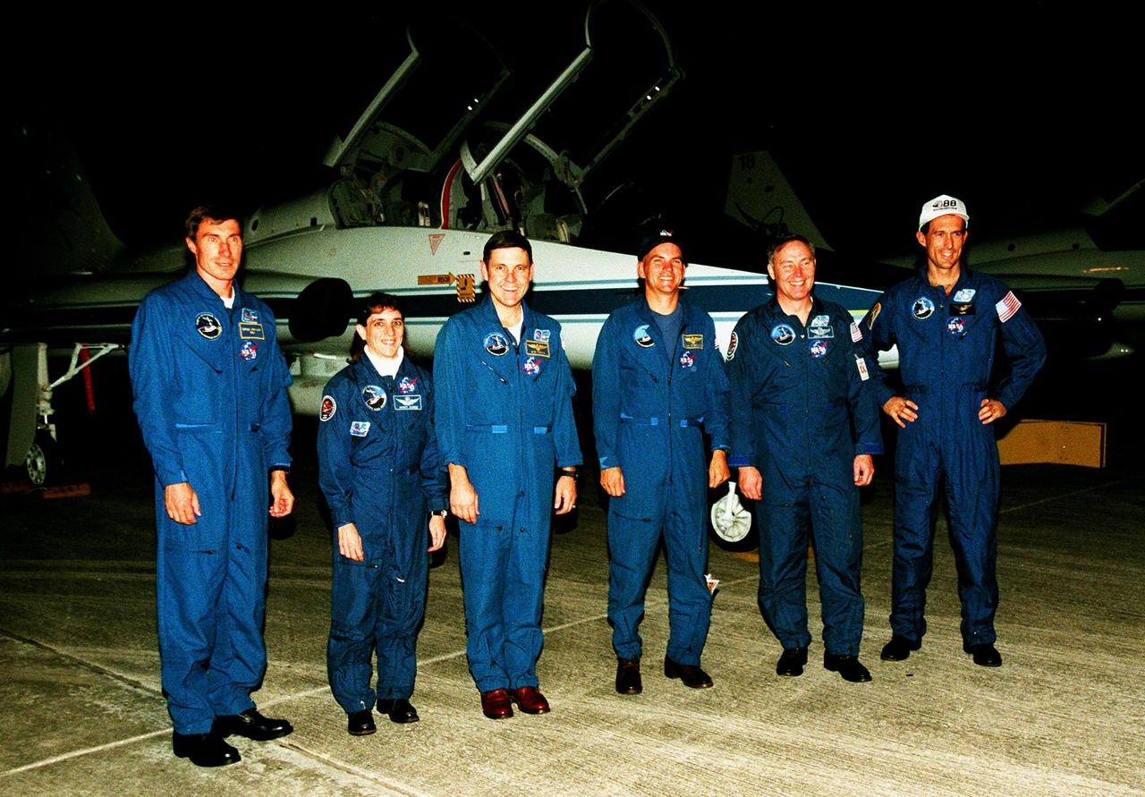 The STS-88 crew members pose for a group photograph in front of a T-38 jet aircraft after their nighttime arrival at the Shuttle Landing Facility to take part in Terminal Countdown Demonstration Test (TCDT) activities. From left to right, they are Mission Specialist Sergei Krikalev, who is a Russian cosmonaut, Mission Specialist Nancy J. Currie, Mission Commander Robert D. Cabana, Pilot Frederick W. "Rick" Sturckow, and Mission Specialists Jerry L. Ross and James H. Newman. The TCDT provides the crew with simulated countdown exercises, emergency egress training, and opportunities to inspect their mission payloads in the orbiter's payload bay. Mission STS-88 is targeted for launch on Dec. 3, 1998. It is the first U.S. flight for the assembly of the International Space Station and will carry the Unity connecting module. Ross and Newman will make three spacewalks to connect power, data and utility lines and install exterior equipment