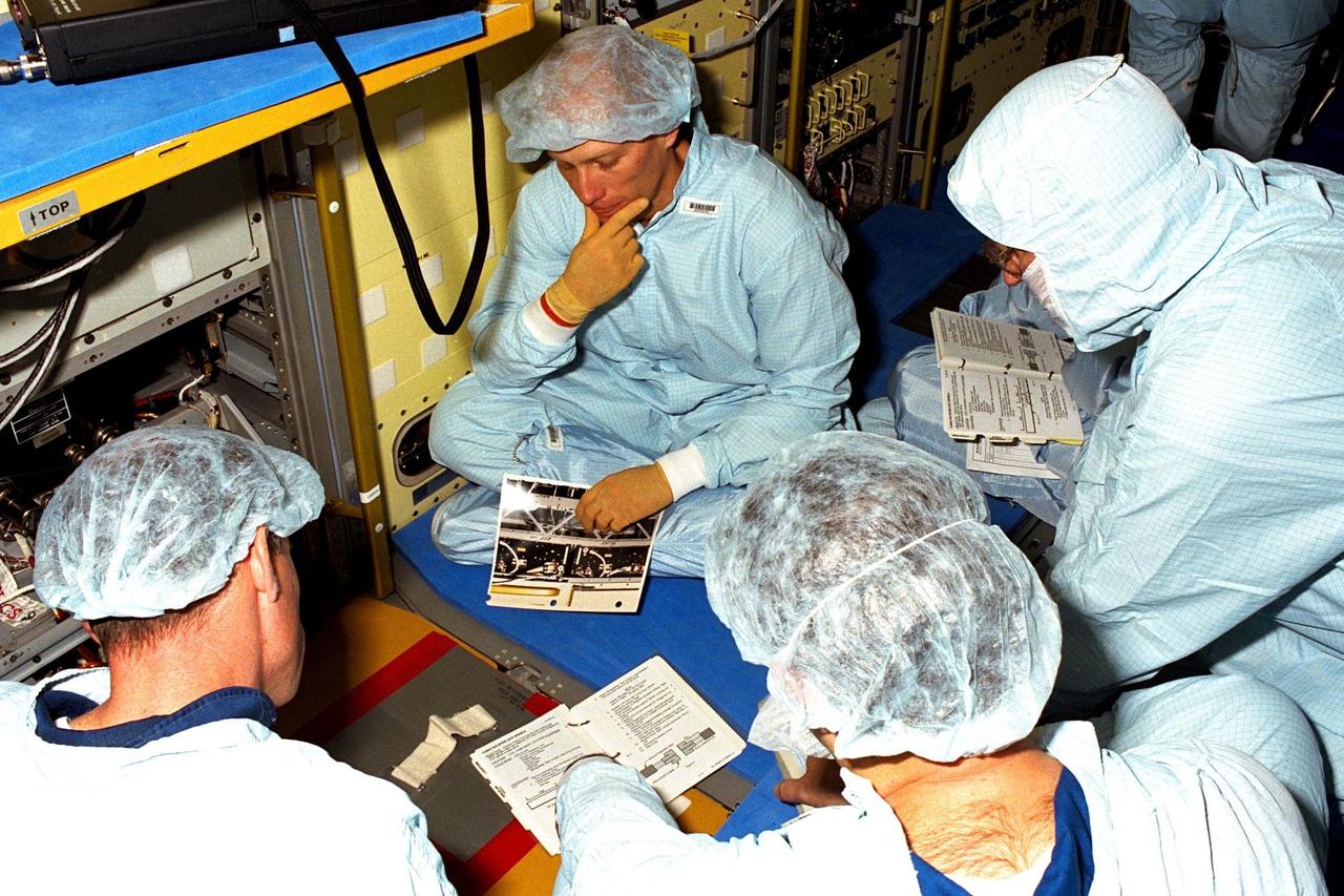 STS-90 crew members study manuals and drawings for the mission's Neurolab payload during the Crew Equipment Interface Test (CEIT) in Kennedy Space Center's (KSC's) Operations and Checkout Building, where the payload is undergoing processing. The CEIT gives astronauts an opportunity to get a hands-on look at the payloads with which they will be working on-orbit. STS-90 is scheduled to launch aboard the Shuttle Columbia from KSC on April 2. Investigations during the Neurolab mission will focus on the effects of microgravity on the nervous system. Specifically, experiments will study the adaptation of the vestibular system, the central nervous system, and the pathways that control the ability to sense location in the absence of gravity, as well as the effect of microgravity on a developing nervous system