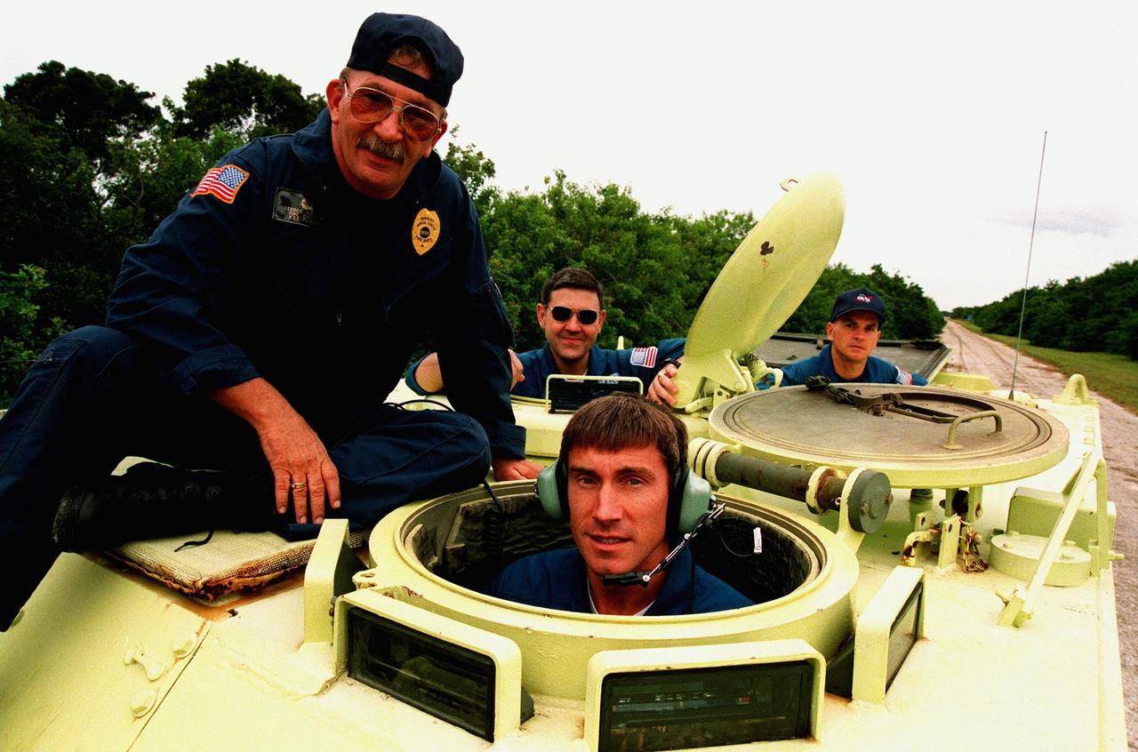 STS-88 Mission Specialist Sergei Konstantinovich Krikalev (center front), a Russian cosmonaut, prepares to operate an M-113, an armored personnel carrier, as part of emergency egress training under the watchful eye of instructor George Hoggard (left) during Terminal Countdown Demonstration Test (TCDT) activities. The TCDT also provides the crew with simulated countdown exercises and opportunities to inspect their mission payloads in the orbiter's payload bay. Mission STS-88 is targeted for launch on Dec. 3, 1998. It is the first U.S. flight for the assembly of the International Space Station and will carry the Unity connecting module. Others in the STS-88 crew are Mission Commander Robert D. Cabana; Pilot Frederick W. "Rick" Sturckow; and Mission Specialists Nancy J. Currie, Jerry L. Ross, and James H. Newman