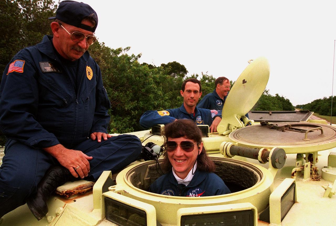 STS-88 Mission Specialist Nancy J. Currie prepares to operate an M-113, an armored personnel carrier, as part of emergency egress training under the watchful eye of instructor George Hoggard (left) during Terminal Countdown Demonstration Test (TCDT) activities. The TCDT also provides the crew with simulated countdown exercises and opportunities to inspect their mission payloads in the orbiter's payload bay. Mission STS-88 is targeted for launch on Dec. 3, 1998. It is the first U.S. flight for the assembly of the International Space Station and will carry the Unity connecting module. Others in the STS-88 crew are Mission Commander Robert D. Cabana; Pilot Frederick W. "Rick" Sturckow; and Mission Specialists Jerry L. Ross, James H. Newman, and Sergei Konstantinovich Krikalev, a Russian cosmonaut
