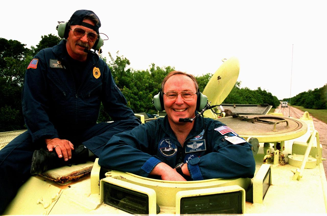 STS-88 Mission Specialist Jerry L. Ross prepares to operate an M-113, an armored personnel carrier, as part of emergency egress training under the watchful eye of instructor George Hoggard (left) during Terminal Countdown Demonstration Test (TCDT) activities. The TCDT also provides the crew with simulated countdown exercises and opportunities to inspect their mission payloads in the orbiter's payload bay. Mission STS-88 is targeted for launch on Dec. 3, 1998. It is the first U.S. flight for the assembly of the International Space Station and will carry the Unity connecting module. Others in the STS-88 crew are Mission Commander Robert D. Cabana; Pilot Frederick W. "Rick" Sturckow; and Mission Specialists Nancy J. Currie, James H. Newman, and Sergei Konstantinovich Krikalev, a Russian cosmonaut
