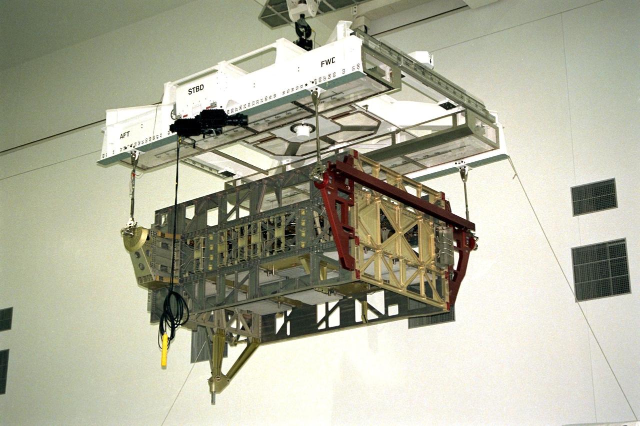 The Photovoltaic Module 1 Integrated Equipment Assembly (IEA) is moved through Kennedy Space Center’s Space Station Processing Facility (SSPF) toward the workstand where it will be processed for flight on STS-97, scheduled for launch in April 1999. The IEA is one of four integral units designed to generate, distribute, and store power for the International Space Station. It will carry solar arrays, power storage batteries, power control units, and a thermal control system. The 16-foot-long, 16,850-pound unit is now undergoing preflight preparations in the SSPF