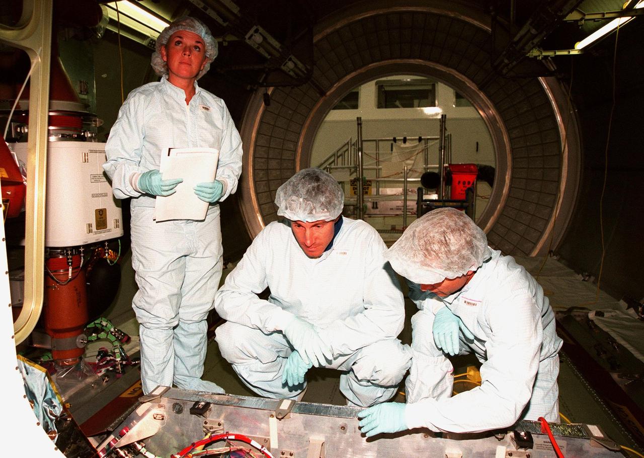 STS-88 Mission Specialist Sergei Konstantinovich Krikalev (center), a Russian cosmonaut, checks out equipment inside a module at the Space Station Processing Facility. Betsy Ahearn (left) and James Burrows, with Boeing, assist him. Mission STS-88 is targeted for launch on Dec. 3, 1998. It is the first U.S. flight for the assembly of the International Space Station and will carry the Unity connecting module