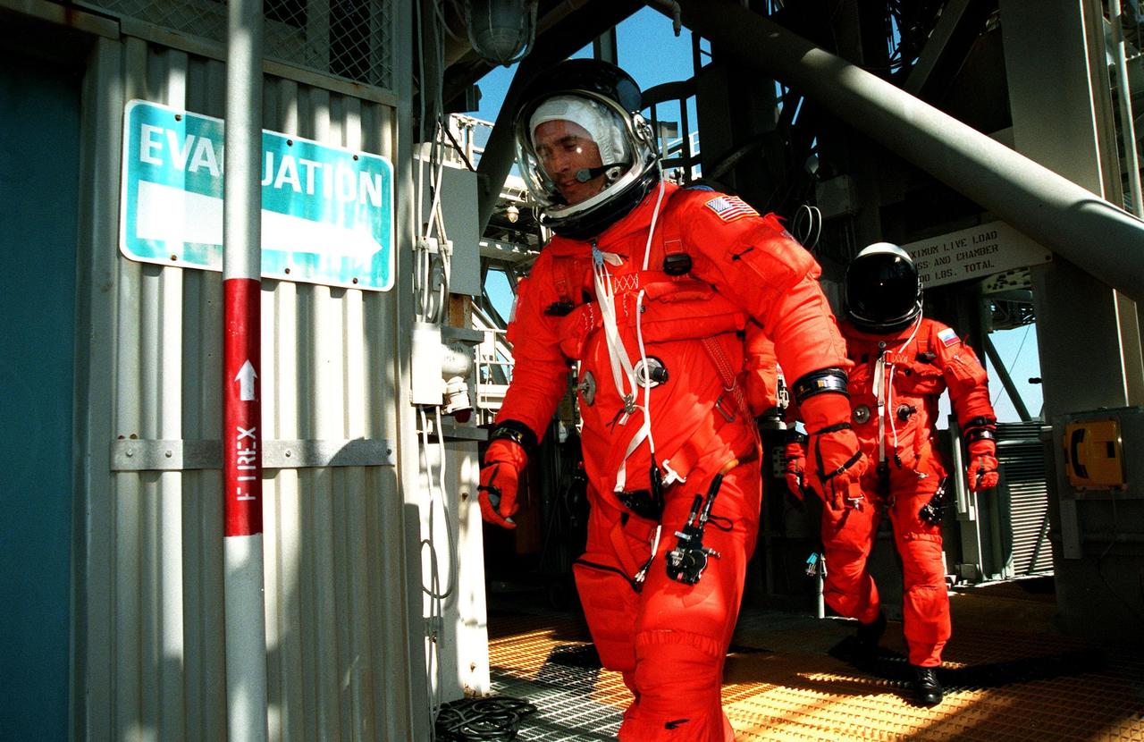 KENNEDY SPACE CENTER,  Fla. -- STS-88 Mission Specialists James H. Newman (left) and Sergei Konstantinovich Krikalev (right) hurry toward the slidewire basket at the 195-foot level of Launch Pad 39A during an emergency egress exercise. The crew are at KSC to participate in the Terminal Countdown Demonstration Test (TCDT) which includes mission familiarization activities, emergency egress training, and the simulated main engine cut-off exercise. Mission STS-88 is targeted for launch on Dec. 3, 1998. It is the first U.S. flight for the assembly of the International Space Station and will carry the Unity connecting module. Unity will be mated with the already orbiting Russian-built Zarya control module. The 12-day mission includes three planned spacewalks to connect power, data and utility lines and install exterior equipment