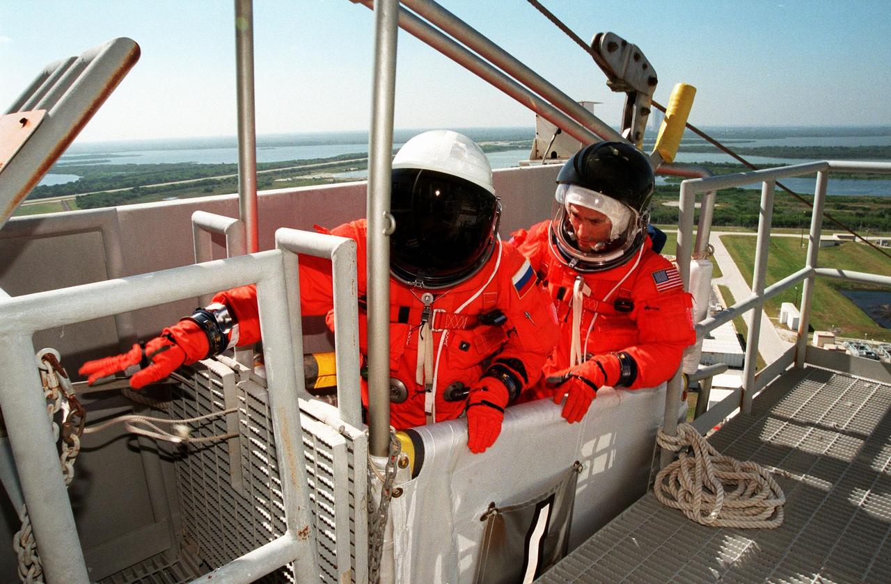 KENNEDY SPACE CENTER,  Fla. -- STS-88 Mission Specialists Sergei Konstantinovich Krikalev (left) and James H. Newman (right) are ready to leave Launch Pad 39A in the slidewire basket during an emergency egress exercise. The crew are at KSC to participate in the Terminal Countdown Demonstration Test (TCDT) which includes mission familiarization activities, emergency egress training, and the simulated main engine cut-off exercise. Mission STS-88 is targeted for launch on Dec. 3, 1998. It is the first U.S. flight for the assembly of the International Space Station and will carry the Unity connecting module. Unity will be mated with the already orbiting Russian-built Zarya control module. The 12-day mission includes three planned spacewalks to connect power, data and utility lines and install exterior equipment
