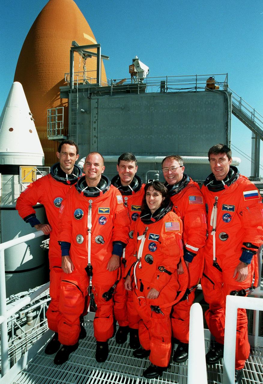 KENNEDY SPACE CENTER, Fla. --  On Launch Pad 39A, the STS-88 crew pose after successfully completing a pre-launch countdown exercise as part of Terminal Countdown Demonstration Test. From left, they are Mission Specialist James H. Newman, Pilot Frederick W. "Rick" Sturckow, Mission Commander Robert D. Cabana, and Mission Specialists Nancy J. Currie, Ph.D., Jerry L. Ross and Sergei Konstantinovich Krikalev, a Russian cosmonaut. Mission STS-88 is targeted for launch on Dec. 3, 1998. It is the first U.S. flight for the assembly of the International Space Station and will carry the Unity connecting module. Unity will be mated with the already orbiting Russian-built Zarya control module. The 12-day mission includes three planned spacewalks to connect power, data and utility lines and install exterior equipment