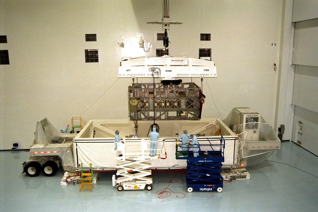 The Photovoltaic Module 1 Integrated Equipment Assembly (IEA) is lifted from its container in Kennedy Space Center’s Space Station Processing Facility (SSPF) before it is moved into its workstand, where it will be processed for flight on STS-97, scheduled for launch in April 1999. The IEA is one of four integral units designed to generate, distribute, and store power for the International Space Station. It will carry solar arrays, power storage batteries, power control units, and a thermal control system. The 16-foot-long, 16,850-pound unit is now undergoing preflight preparations in the SSPF