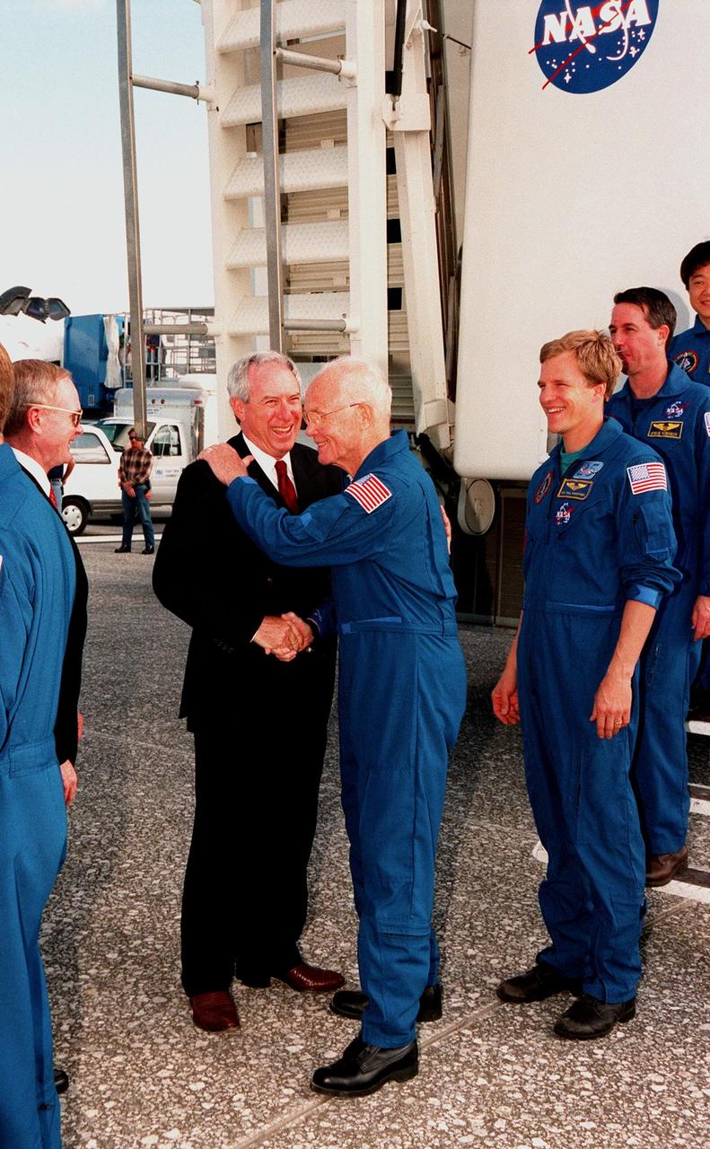 Following touchdown at 12:04 p.m. EST at the Shuttle Landing Facility, the mission STS-95 crew leave the Crew Transport Vehicle. Payload Specialist John H. Glenn Jr. (center), a senator from Ohio, shakes hands with NASA Administrator Daniel S. Goldin. At left is Center Director Roy Bridges. Other crew members shown are Pilot Steven W. Lindsey (far left) and, behind Glenn, Mission Specialists Scott E. Parazynski and Stephen K. Robinson, and Payload Specialist Chiaki Mukai, Ph.D., M.D., with the National Space Development Agency of Japan. Not seen are Mission Commander Curtis L. Brown Jr. and Mission Specialist Pedro Duque of Spain, with the European Space Agency (ESA). The STS-95 crew completed a successful mission, landing at the Shuttle Landing Facility at 12:04 p.m. EST, after 9 days in space, traveling 3.6 million miles. The mission included research payloads such as the Spartan solar-observing deployable spacecraft, the Hubble Space Telescope Orbital Systems Test Platform, the International Extreme Ultraviolet Hitchhiker, as well as the SPACEHAB single module with experiments on space flight and the aging process