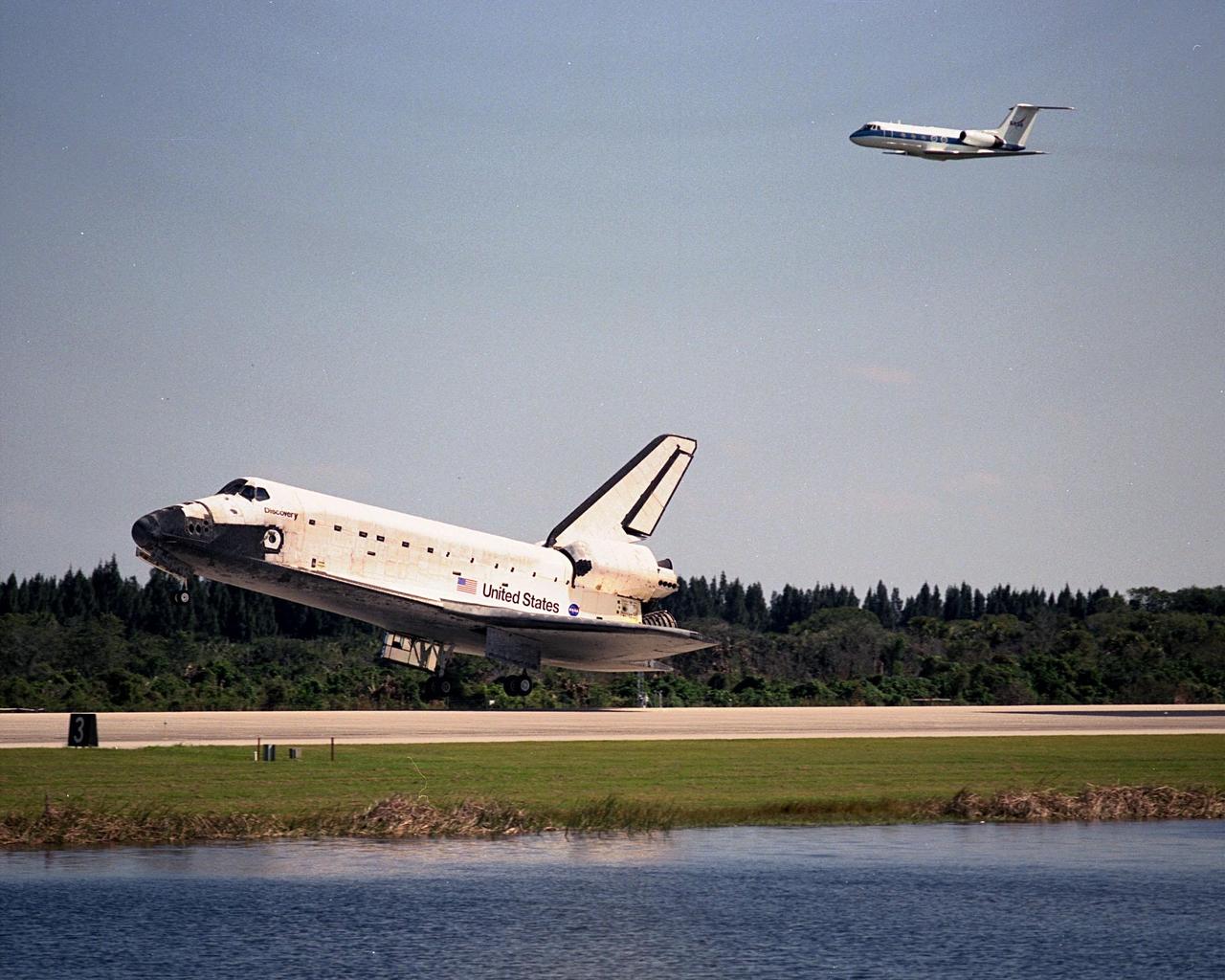 The Shuttle Training Aircraft (top) seems to chase orbiter Discovery as it touches down at the Shuttle Landing Facility after a successful mission of nearly nine days and 3.6 million miles. Main gear touchdown was at 12:04 p.m. EST, landing on orbit 135. In the background, right, is the Vehicle Assembly Building. The STS-95 crew consists of Mission Commander Curtis L. Brown Jr.; Pilot Steven W. Lindsey; Mission Specialist Scott E. Parazynski; Mission Specialist Stephen K. Robinson; Payload Specialist John H. Glenn Jr., senator from Ohio; Mission Specialist Pedro Duque, with the European Space Agency (ESA); and Payload Specialist Chiaki Mukai, with the National Space Development Agency of Japan (NASDA). The mission included research payloads such as the Spartan solar-observing deployable spacecraft, the Hubble Space Telescope Orbital Systems Test Platform, the International Extreme Ultraviolet Hitchhiker, as well as the SPACEHAB single module with experiments on space flight and the aging process