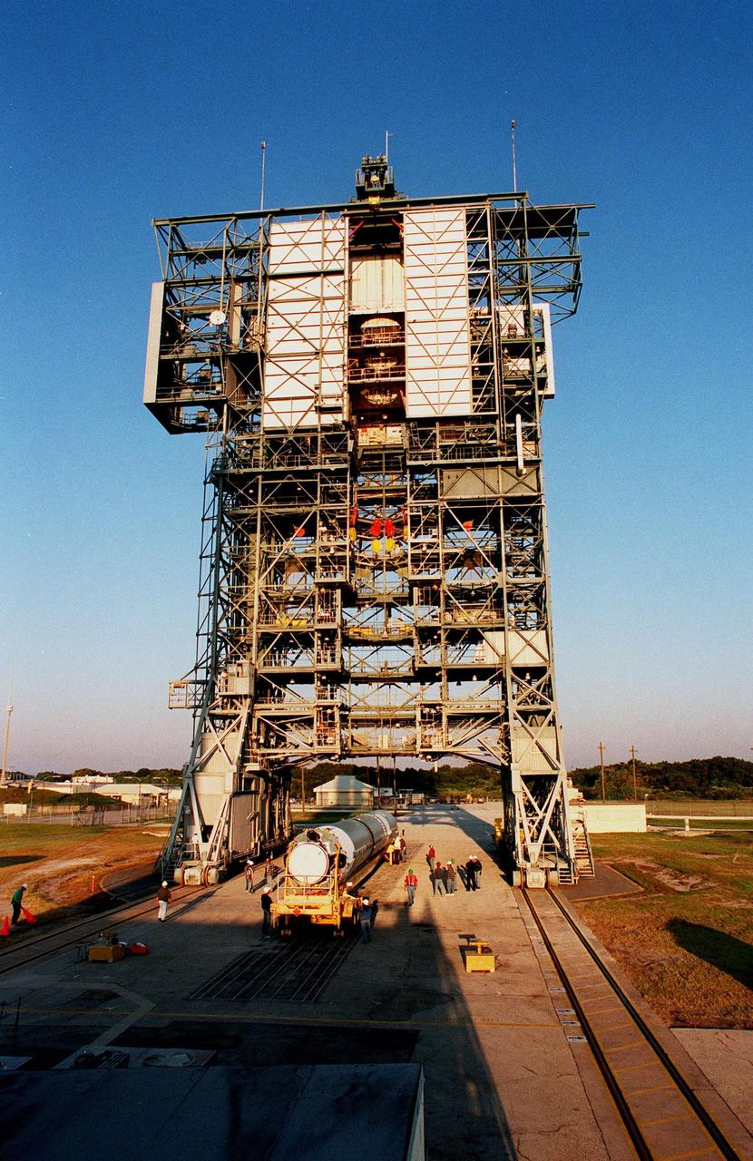 KENNEDY SPACE CENTER, FLA. -- The gantry on Pad 17A at Cape Canaveral Air Station appears to straddle the Delta II rocket below it that is being moved into position for lifting. The rocket is scheduled for launch on Dec. 10, 1998, carrying the Mars Climate Orbiter. The orbiter is heading for Mars where it will primarily support its companion Mars Polar Lander spacecraft, which is planned for launch on Jan. 3, 1999. The orbiter's instruments will monitor the Martian atmosphere and image the planet's surface on a daily basis for one Martian year (1.8 Earth years). It will observe the appearance and movement of atmospheric dust and water vapor, as well as characterize seasonal changes on the surface. The detailed images of the surface features will provide important clues to the planet's early climate history and give scientists more information about possible liquid water reserves beneath the surface
