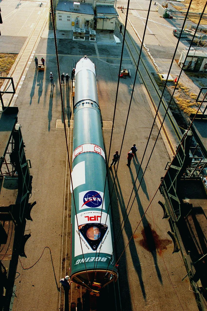 KENNEDY SPACE CENTER, FLA. -- On Pad 17A at Cape Canaveral Air Station, cables from the top of the gantry are attached to the Delta II rocket to lift it into position for launch. Scheduled to launch Dec. 10, 1998, the rocket will be carrying the Mars Climate Orbiter. The orbiter is heading for Mars where it will primarily support its companion Mars Polar Lander spacecraft, which is planned for launch on Jan. 3, 1999. The orbiter's instruments will monitor the Martian atmosphere and image the planet's surface on a daily basis for one Martian year (1.8 Earth years). It will observe the appearance and movement of atmospheric dust and water vapor, as well as characterize seasonal changes on the surface. The detailed images of the surface features will provide important clues to the planet's early climate history and give scientists more information about possible liquid water reserves beneath the surface