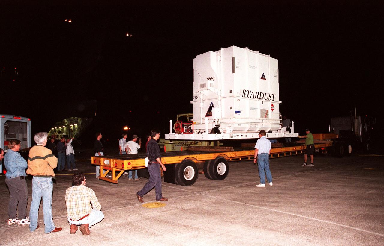 At the Shuttle Landing Facility, workers observe the loading of the crated Stardust spacecraft onto a trailer for transporting to the Payload Hazardous Service Facility. Built by Lockheed Martin Astronautics near Denver, Colo., for the Jet Propulsion Laboratory (JPL) and NASA, the spacecraft Stardust will use a unique medium called aerogel to capture comet particles flying off the nucleus of comet Wild 2 in January 20004, plus collect interstellar dust for later analysis. Stardust will be launched aboard a Boeing Delta 7426 rocket from Complex 17, Cape Canaveral Air Station, targeted for Feb. 6, 1999. The collected samples will return to Earth in a re-entry capsule to be jettisoned from Stardust as it swings by in January 2006