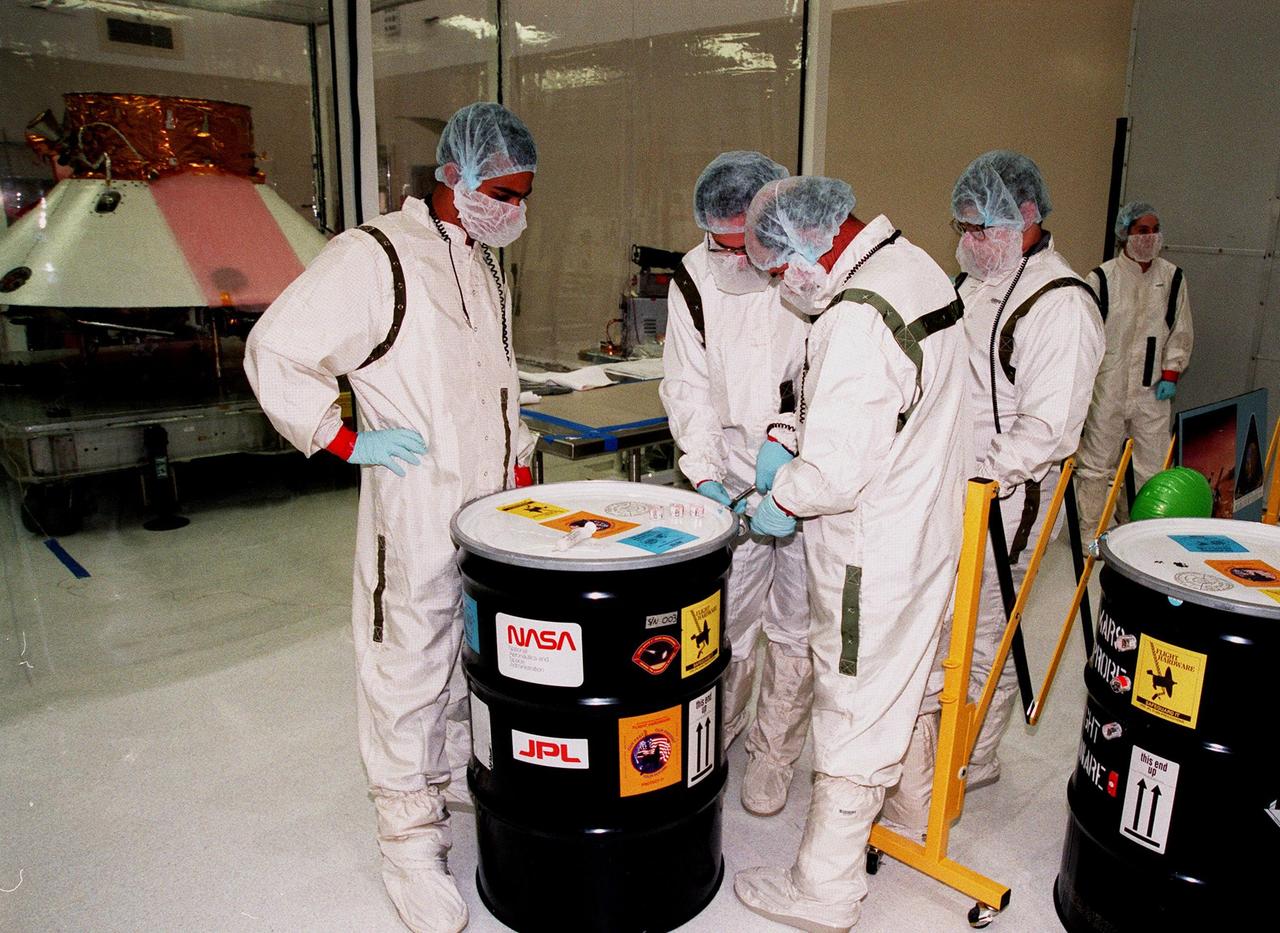 KENNEDY SPACE CENTER, FLA. -- In the Spacecraft Assembly and Encapsulation Facility -2 (SAEF-2), workers from the Jet Propulsion Laboratory open the drums containing the Mars microprobes that will hitchhike on the Mars Polar Lander. From left, they are Satish Krishnan, Charles Cruzan, Chris Voorhees and Arden Acord. Scheduled to be launched Jan. 3, 1999, aboard a Delta II rocket, the solar-powered spacecraft is designed to touch down on the Martian surface near the northern-most boundary of the south pole in order to study the water cycle there. The lander also will help scientists learn more about climate change and current resources on Mars, studying such things as frost, dust, water vapor and condensates in the Martian atmosphere. The Mars microprobes, called Deep Space 2, are part of NASA's New Millennium Program. They will complement the climate-related scientific focus of the lander by demonstrating an advanced, rugged microlaser system for detecting subsurface water. Such data on polar subsurface water, in the form of ice, should help put limits on scientific projections for the global abundance of water on Mars