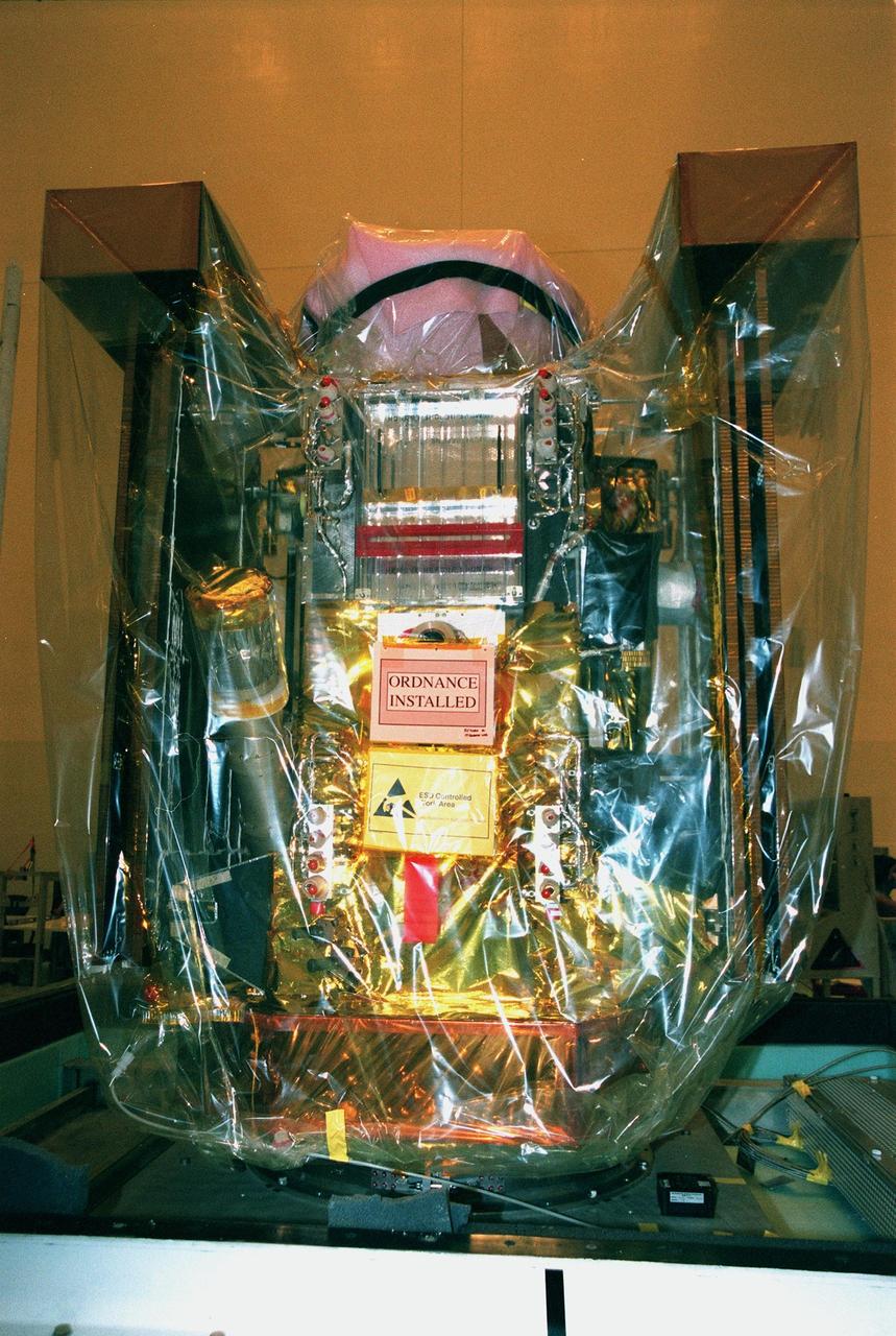 In the Payload Hazardous Service Facility, the Stardust spacecraft sits wrapped in plastic covering. Built by Lockheed Martin Astronautics near Denver, Colo., for the Jet Propulsion Laboratory (JPL) and NASA, the spacecraft Stardust will use a unique medium called aerogel to capture comet particles and interstellar dust for later analysis. Stardust will be launched aboard a Boeing Delta 7426 rocket targeted for Feb. 6, 1999. The collected samples will return to Earth in a re-entry capsule to be jettisoned from Stardust as it swings by Earth in January 2006