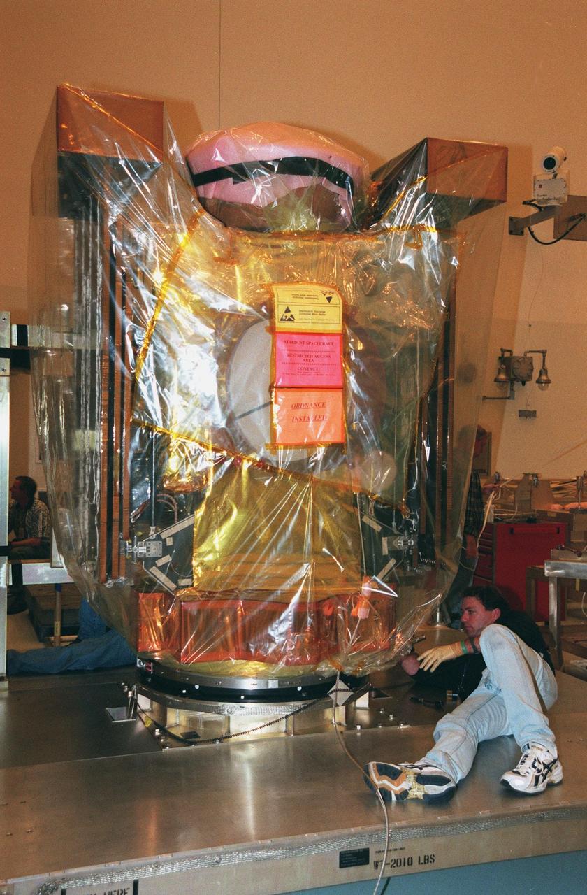 In the Payload Hazardous Service Facility, workers lower the Stardust spacecraft onto a workstand. The spacecraft will undergo installation and testing of the solar arrays, plus final installation and testing of spacecraft instruments followed by an overall spacecraft functional test. Built by Lockheed Martin Astronautics near Denver, Colo., for the Jet Propulsion Laboratory (JPL) and NASA, the spacecraft Stardust will use a unique medium called aerogel to capture comet particles flying off the nucleus of comet Wild 2 in January 2004, plus collect interstellar dust for later analysis. Stardust will be launched aboard a Boeing Delta 7426 rocket from Complex 17, Cape Canaveral Air Station, targeted for Feb. 6, 1999. The collected samples will return to Earth in a re-entry capsule to be jettisoned from Stardust as it swings by Earth in January 2006