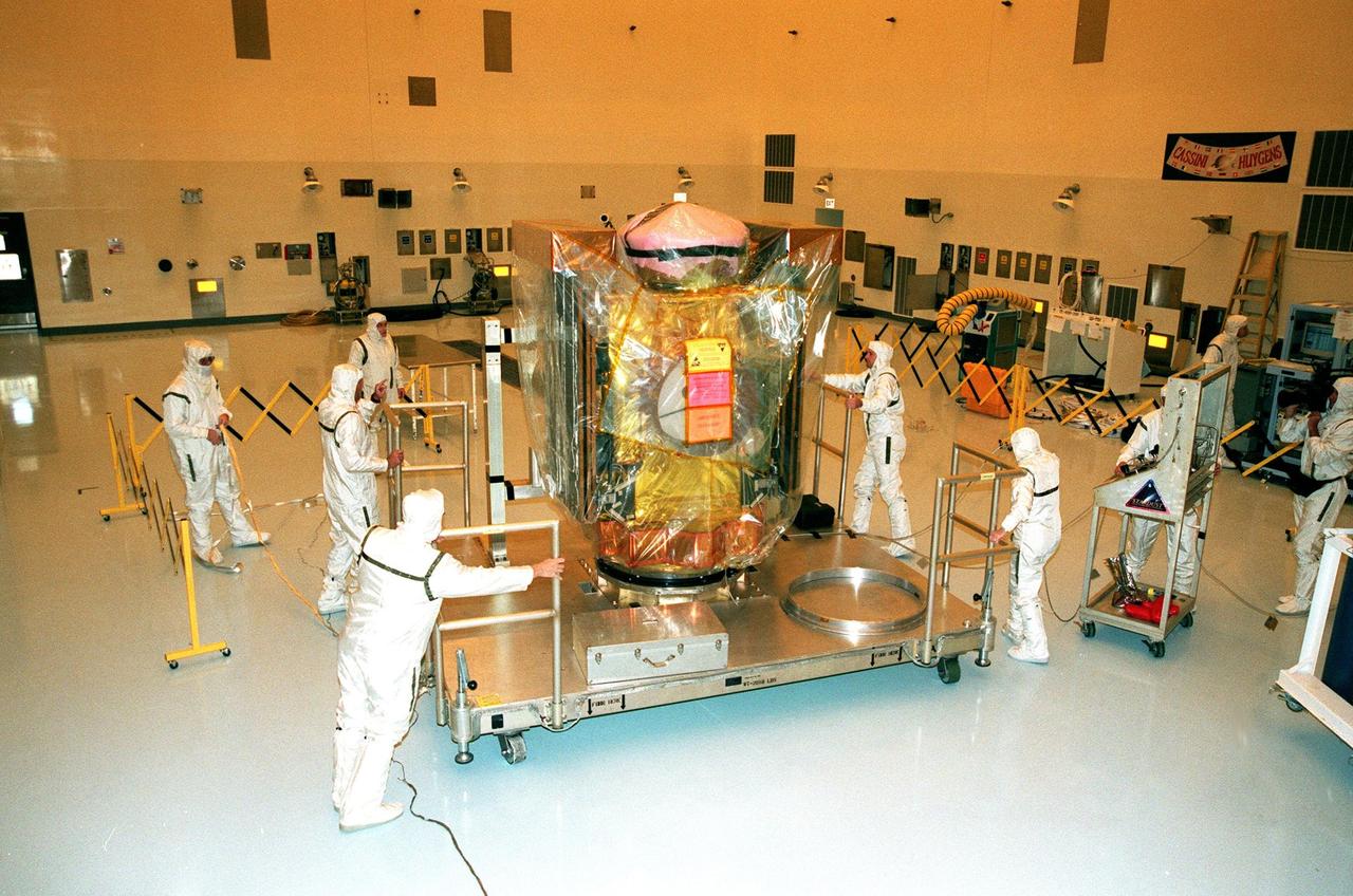 In the Payload Hazardous Service Facility, workers move the Stardust spacecraft on its workstand from the air lock to the high bay. The spacecraft will undergo installation and testing of the solar arrays, plus final installation and testing of spacecraft instruments followed by an overall spacecraft functional test. Built by Lockheed Martin Astronautics near Denver, Colo., for the Jet Propulsion Laboratory (JPL) and NASA, the spacecraft Stardust will use a unique medium called aerogel to capture comet particles flying off the nucleus of comet Wild 2 in January 2004, plus collect interstellar dust for later analysis. Stardust will be launched aboard a Boeing Delta 7426 rocket from Complex 17, Cape Canaveral Air Station, targeted for Feb. 6, 1999. The collected samples will return to Earth in a re-entry capsule to be jettisoned from Stardust as it swings by Earth in January 2006