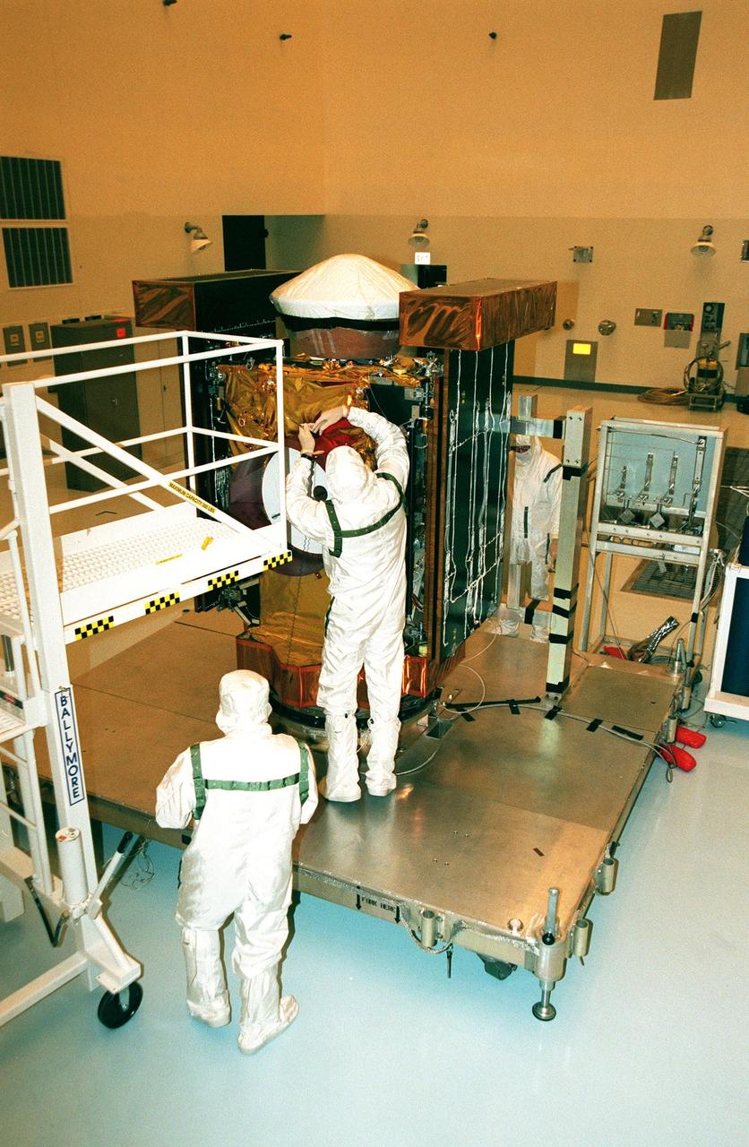 In the Payload Hazardous Service Facility, workers begin checking the Stardust spacecraft after removing its protective cover. The spacecraft will undergo installation and testing of the solar arrays, plus final installation and testing of spacecraft instruments followed by an overall spacecraft functional test. Built by Lockheed Martin Astronautics near Denver, Colo., for the Jet Propulsion Laboratory (JPL) and NASA, the spacecraft Stardust will use a unique medium called aerogel to capture comet particles flying off the nucleus of comet Wild 2 in January 2004, plus collect interstellar dust for later analysis. Stardust will be launched aboard a Boeing Delta 7426 rocket from Complex 17, Cape Canaveral Air Station, targeted for Feb. 6, 1999. The collected samples will return to Earth in a re-entry capsule to be jettisoned from Stardust as it swings by Earth in January 2006