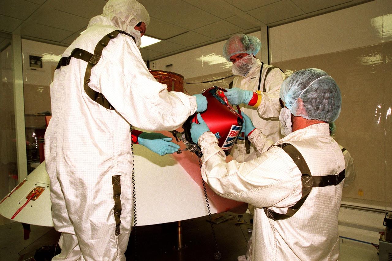 KENNEDY SPACE CENTER, FLA. -- In the Spacecraft Assembly and Encapsulation Facility -2 (SAEF-2), JPL workers mount a Mars microprobe onto the Mars Polar Lander. Two microprobes will hitchhike on the lander, scheduled to be launched Jan. 3, 1999, aboard a Delta II rocket. The solar-powered spacecraft is designed to touch down on the Martian surface near the northern-most boundary of the south pole in order to study the water cycle there. The lander also will help scientists learn more about climate change and current resources on Mars, studying such things as frost, dust, water vapor and condensates in the Martian atmosphere. The Mars microprobes, called Deep Space 2, are part of NASA's New Millennium Program. They will complement the climate-related scientific focus of the lander by demonstrating an advanced, rugged microlaser system for detecting subsurface water. Such data on polar subsurface water, in the form of ice, should help put limits on scientific projections for the global abundance of water on Mars