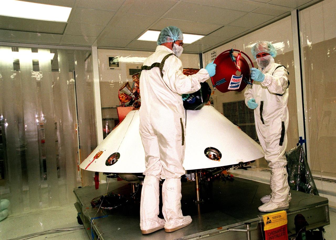 KENNEDY SPACE CENTER, FLA. -- In the Spacecraft Assembly and Encapsulation Facility -2 (SAEF-2), JPL workers prepare to mount a Mars microprobe onto the Mars Polar Lander. Two microprobes will hitchhike on the lander, scheduled to be launched Jan. 3, 1999, aboard a Delta II rocket. The solar-powered spacecraft is designed to touch down on the Martian surface near the northern-most boundary of the south pole in order to study the water cycle there. The lander also will help scientists learn more about climate change and current resources on Mars, studying such things as frost, dust, water vapor and condensates in the Martian atmosphere. The Mars microprobes, called Deep Space 2, are part of NASA's New Millennium Program. They will complement the climate-related scientific focus of the lander by demonstrating an advanced, rugged microlaser system for detecting subsurface water. Such data on polar subsurface water, in the form of ice, should help put limits on scientific projections for the global abundance of water on Mars