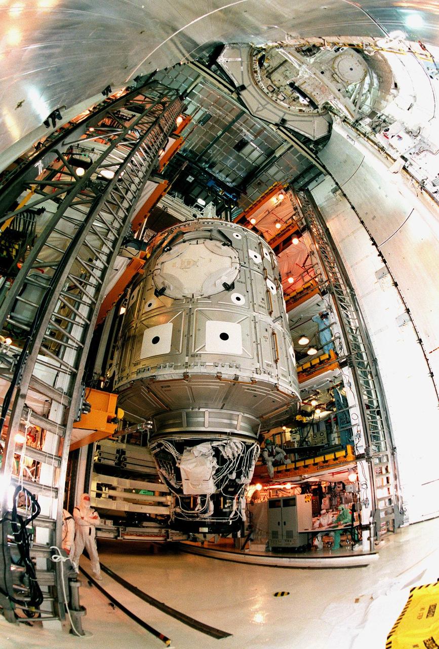 Looking like a painting, this wide-angle view shows the Unity connecting module being moved toward the payload bay of the orbiter Endeavour at Launch Pad 39A. Part of the International Space Station (ISS), Unity is scheduled for launch Dec. 3, 1998, on Mission STS-88. The Unity is a connecting passageway to the living and working areas of ISS. While on orbit, the flight crew will deploy Unity from the payload bay and attach it to the Russian-built Zarya control module which will be in orbit at that time