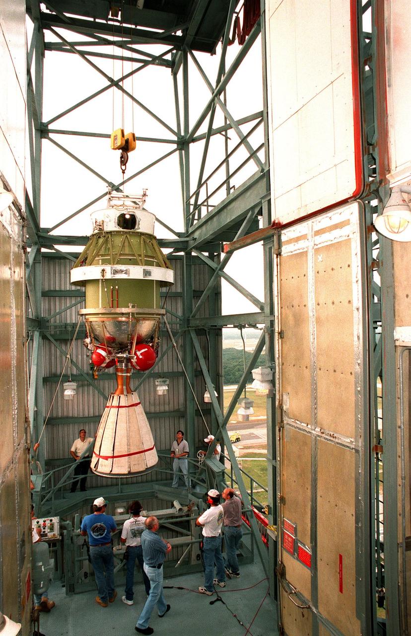 Workers at pad 17A at Cape Canaveral Air Station maneuver the second stage of a Delta II rocket inside the gantry. The rocket is scheduled to be launched on Dec. 10, 1998, heading for Mars and carrying the Mars Climate Orbiter. The orbiter's instruments will monitor the Martian atmosphere and image the planet's surface on a daily basis for 657 days. It will observe the appearance and movement of atmospheric dust and water vapor, as well as characterize seasonal changes on the surface. The detailed images of the surface features will provide important clues to the planet's early climate history and give scientists more information about possible liquid water reserves beneath the surface. The orbiter will primarily support its companion Mars Polar Lander spacecraft, which is planned for launch on Jan. 3, 1999