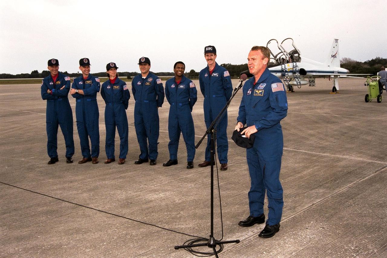 The STS-89 crew speak with the press after arriving at Kennedy Space Center's Shuttle Landing Facility in preparation for launch later this week. From left to right the crew include Commander Terrence Wilcutt; Pilot Joe Edwards Jr.; and Mission Specialists Bonnie Dunbar, Ph.D.; Salizhan Sharipov with the Russian Space Agency; Michael Anderson; James Reilly, Ph.D.; and Andrew Thomas, Ph.D. (at microphone). Dr. Thomas will succeed David Wolf, M.D., on the Russian Space Station Mir. Launch is scheduled for January 22 at 9:48 p.m. EST