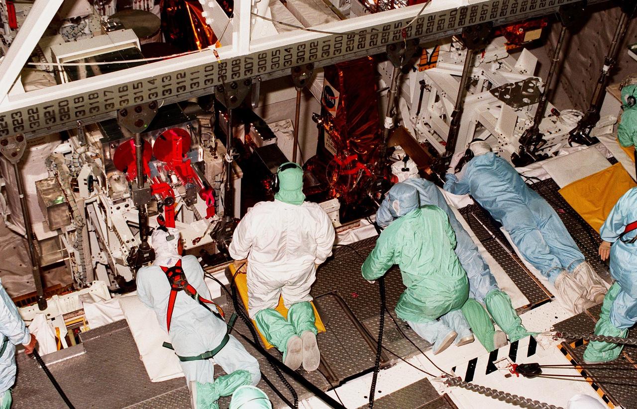 Workers in the Orbiter Processing Facility prepare to unload the STS-95 payloads in front of them from the payload bay of the orbiter Discovery. The experiments will be returned to their respective hosts. The mission included the Spartan solar-observing deployable spacecraft, the Hubble Space Telescope Orbital Systems Test Platform, the International Extreme Ultraviolet Hitchhiker, as well as the SPACEHAB single module with experiments on space flight and the aging process