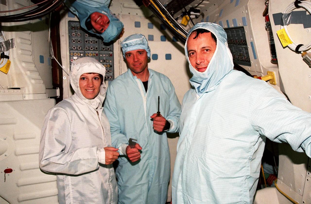 In the Orbiter Processing Facility Bay 3, during the Crew Equipment Interface Test (CEIT) for mission STS-93, crew members pose for a photograph . From left they are Mission Commander Eileen M. Collins, Pilot Jeffrey S. Ashby, and Mission Specialist Michel Tognini of France. Above Ashby's head is Mission Specialist Catherine G. Coleman. Not shown is Mission Specialist Steven A. Hawley. Collins is the first woman to serve as a mission commander on a shuttle flight. The CEIT provides an opportunity for crew members to check equipment and facilities that will be aboard the orbiter during their mission. The STS-93 mission will deploy the Advanced X-ray Astrophysics Facility (AXAF), which comprises three major elements: the spacecraft, the telescope, and the science instrument module (SIM). AXAF will allow scientists from around the world to obtain unprecedented X-ray images of a variety of high-energy objects to help understand the structure and evolution of the universe. Targeted date for the launch of STS-93 is March 18, 1999