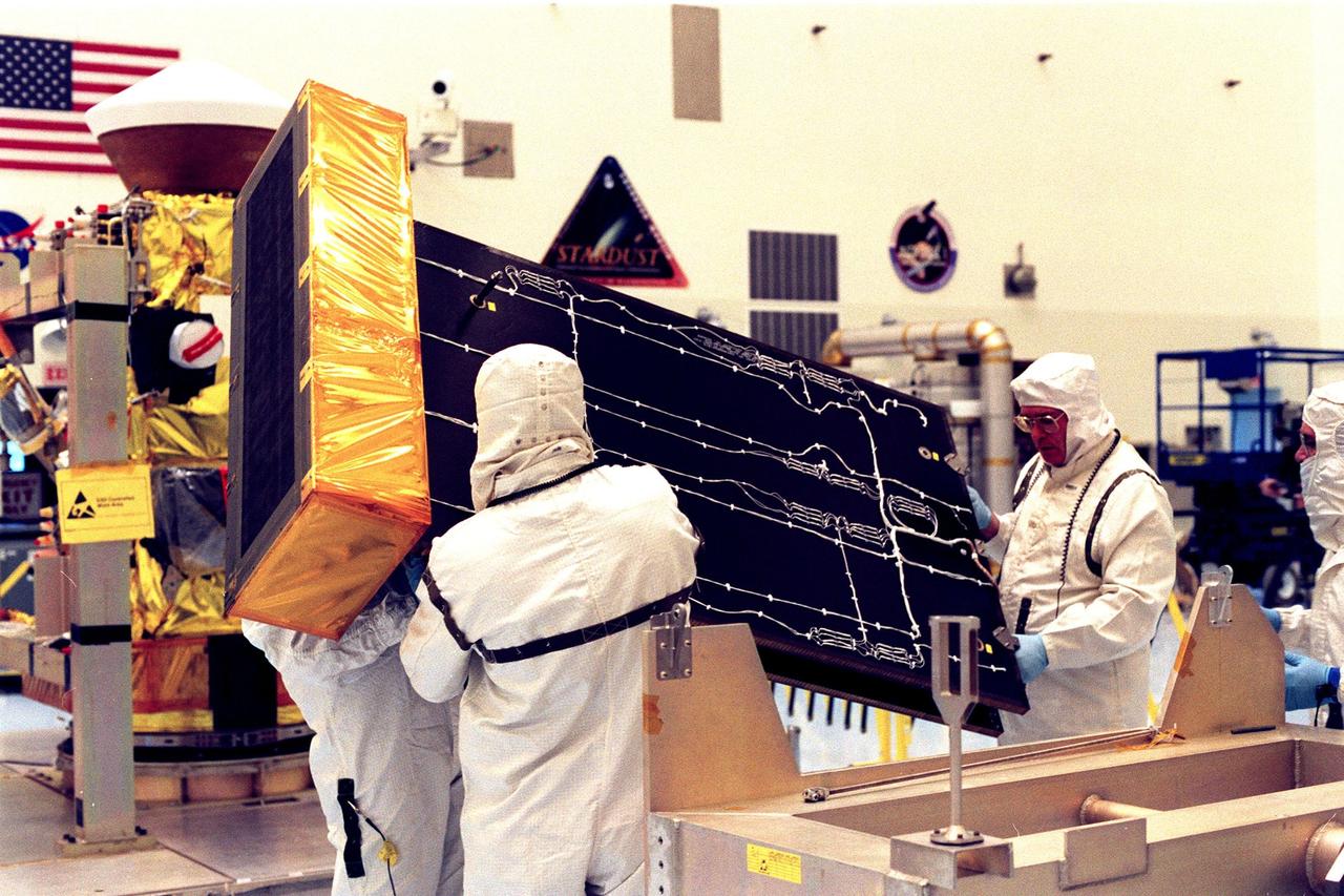 In the Payload Hazardous Servicing Facility, workers carry one of the Stardust solar panels removed for testing. The spacecraft Stardust will use a unique medium called aerogel to capture comet particles flying off the nucleus of comet Wild 2 in January 2004, plus collect interstellar dust for later analysis. Stardust will be launched aboard a Boeing Delta 7426 rocket from Complex 17, Cape Canaveral Air Station, targeted for Feb. 6, 1999. The collected samples will return to Earth in a re-entry capsule to be jettisoned from Stardust as it swings by Earth in January 2006
