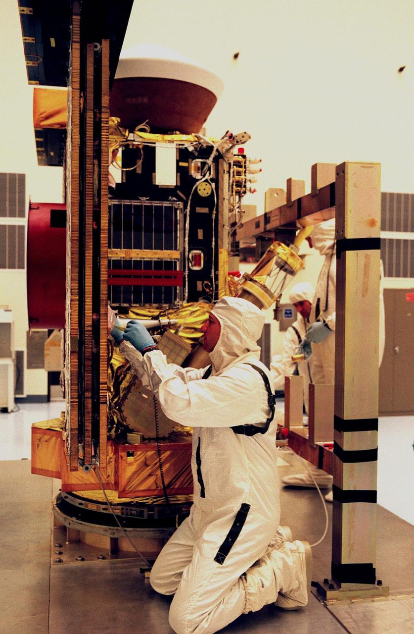 In the Payload Hazardous Servicing Facility, workers remove the Stardust solar panels for testing. The spacecraft Stardust will use a unique medium called aerogel to capture comet particles flying off the nucleus of comet Wild 2 in January 2004, plus collect interstellar dust for later analysis. Stardust will be launched aboard a Boeing Delta 7426 rocket from Complex 17, Cape Canaveral Air Station, targeted for Feb. 6, 1999. The collected samples will return to Earth in a re-entry capsule (seen at the top of the spacecraft in this photo) to be jettisoned from Stardust as it swings by Earth in January 2006