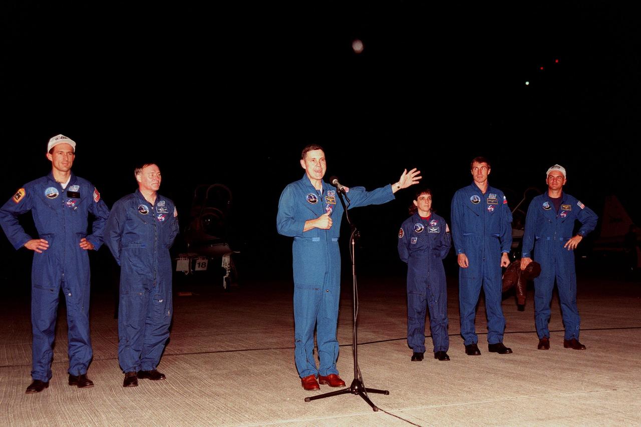 Shortly after their arrival at the Shuttle Landing Facility, STS-88 crew members talk to the media. From left, they are Mission Specialists James H. Newman and Jerry L. Ross, Commander Robert D. Cabana (at microphone), Mission Specialists Nancy J. Currie and Sergei Konstantinovich Krikalev, and Pilot Frederick W. "Rick" Sturckow. Krikalev is a Russian cosmonaut who has flown three times in space, once on the Space Shuttle and twice aboard the Russian Space Station Mir. The STS-88 mission is the fourth spaceflight for Cabana, sixth for Ross, third for Currie, third for Newman and first for Sturckow. The scheduled time of launch is 3:56 a.m. EST on Dec. 3 from Launch Pad 39A. The mission is the first U.S. launch for the International Space Station. Endeavour carries the Unity connecting module which the crew will be mating with the Russian-built Zarya control module already in orbit. In addition to Unity, Endeavour will carry two small replacement electronics boxes for possible repairs to Zarya batteries. The mission is scheduled to last nearly 12 days