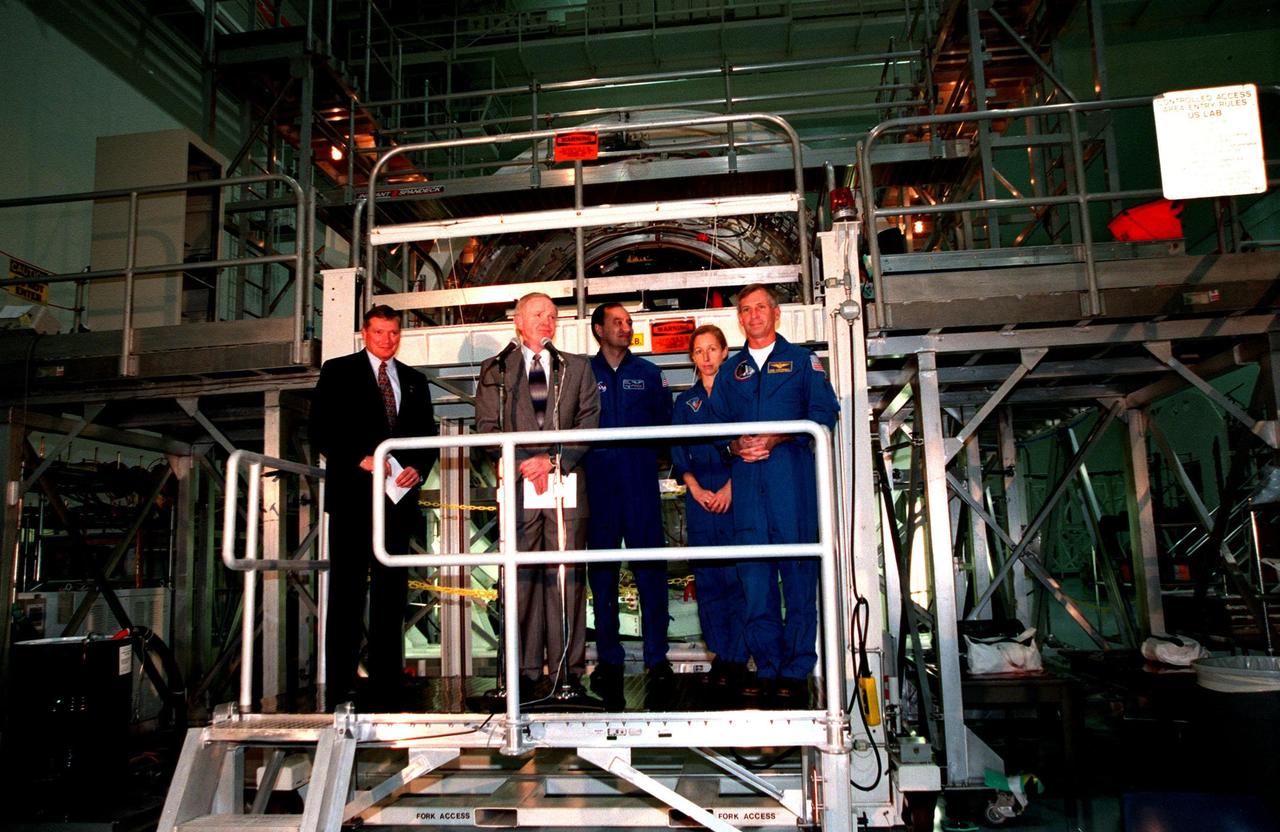 KENNEDY SPACE CENTER, FLA. -- In the Space Station Processing Facility, Center Director Roy Bridges (left), Program Manager of the International Space Station (ISS) Randy Brinkley (second from left) and (right) STS-98 Commander Ken Cockrell applaud the unveiling of the name Destiny given the U.S. Lab module. The lab, which is behind them on a workstand, is scheduled to be launched on Space Shuttle Endeavour in early 2000. It will become the centerpiece of scientific research on the ISS. Cockrell is part of the five-member crew expected to be aboard. The Shuttle will spend six days docked to the station while the laboratory is attached and three space walks are conducted to complete its assembly. The laboratory will be launched with five equipment racks aboard, which will provide essential functions for station systems, including high data-rate communications, and maintain the station's orientation using control gyroscopes launched earlier. Additional equipment and research racks will be installed in the laboratory on subsequent Shuttle flights