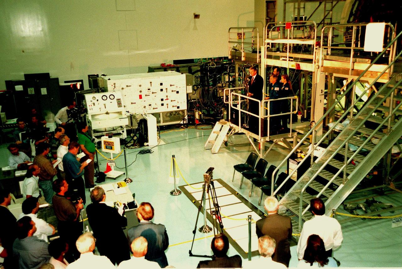 KENNEDY SPACE CENTER, FLA. -- In the Space Station Processing Facility, Program Manager of the International Space Station (ISS) Randy Brinkley addresses the media before lowering the banner to unveil the name of "Destiny" given the U.S. Lab module, the centerpiece of scientific research on the ISS. With Brinkley on the stand are Center Director Roy Bridges (behind him on the left), and (the other side, left to right) STS-98 Commander Ken Cockrell, Pilot Mark Polansky, and Mission Specialist Marsha Ivins. The lab, which is behind them on a workstand, is scheduled to be launched on Space Shuttle Endeavour in early 2000. It will become the centerpiece of scientific research on the International Space Station. Polansky, Cockrel and Ivins are part of the five-member crew expected to be aboard. The Shuttle will spend six days docked to the station while the laboratory is attached and three space walks are conducted to complete its assembly. The laboratory will be launched with five equipment racks aboard, which will provide essential functions for station systems, including high data-rate communications, and maintain the station's orientation using control gyroscopes launched earlier. Additional equipment and research racks will be installed in the laboratory on subsequent Shuttle flights