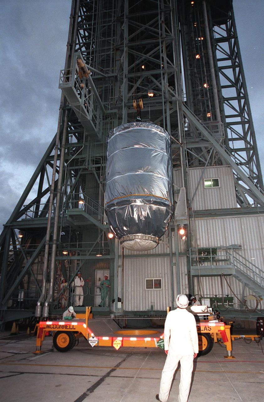 KENNEDY SPACE CENTER, FLA. -- Wrapped in a protective covering, the Mars Climate Orbiter with its upper stage booster is lifted up at Launch Complex 17, Pad A, Cape Canaveral Air Station, in preparation for mating to the second stage of a Boeing Delta II (7425) rocket. Targeted for liftoff on Dec. 10, 1998, the orbiter will be the first spacecraft to be launched in the pair of Mars ’98 missions. After its arrival at the red planet, the Mars Climate Orbiter will be used primarily to support its companion Mars Polar Lander spacecraft, scheduled for launch on Jan. 3, 1999. The orbiter will then monitor the Martian atmosphere and image the planet’s surface on a daily basis for one Martian year, the equivalent of about two Earth years. The spacecraft will observe the appearance and movement of atmospheric dust and water vapor, and characterize seasonal changes on the planet’s surface