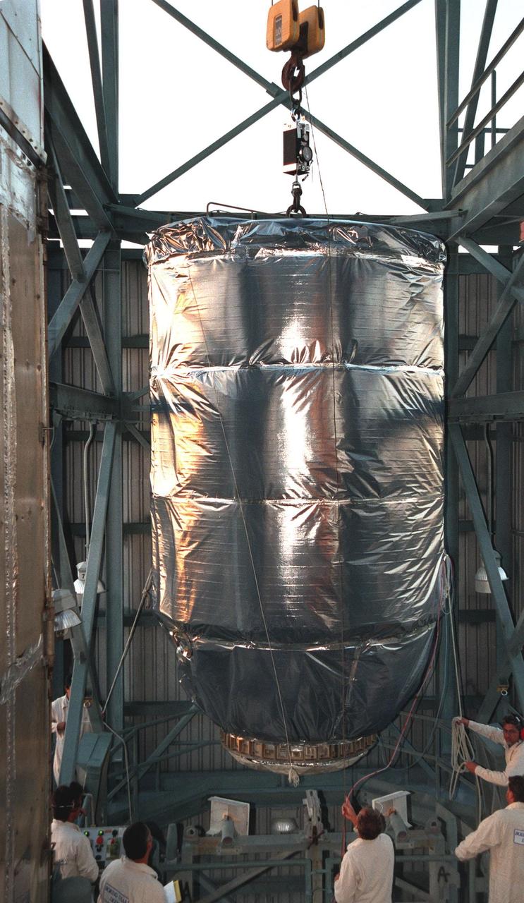 KENNEDY SPACE CENTER, FLA. -- Wrapped in a protective covering, the Mars Climate Orbiter with its upper stage booster is lifted up at Launch Complex 17, Pad A, Cape Canaveral Air Station, in preparation for mating to the second stage of a Boeing Delta II (7425) rocket. Targeted for liftoff on Dec. 10, 1998, the orbiter will be the first spacecraft to be launched in the pair of Mars ’98 missions. After its arrival at the red planet, the Mars Climate Orbiter will be used primarily to support its companion Mars Polar Lander spacecraft, scheduled for launch on Jan. 3, 1999. The orbiter will then monitor the Martian atmosphere and image the planet’s surface on a daily basis for one Martian year, the equivalent of about two Earth years. The spacecraft will observe the appearance and movement of atmospheric dust and water vapor, and characterize seasonal changes on the planet’s surface