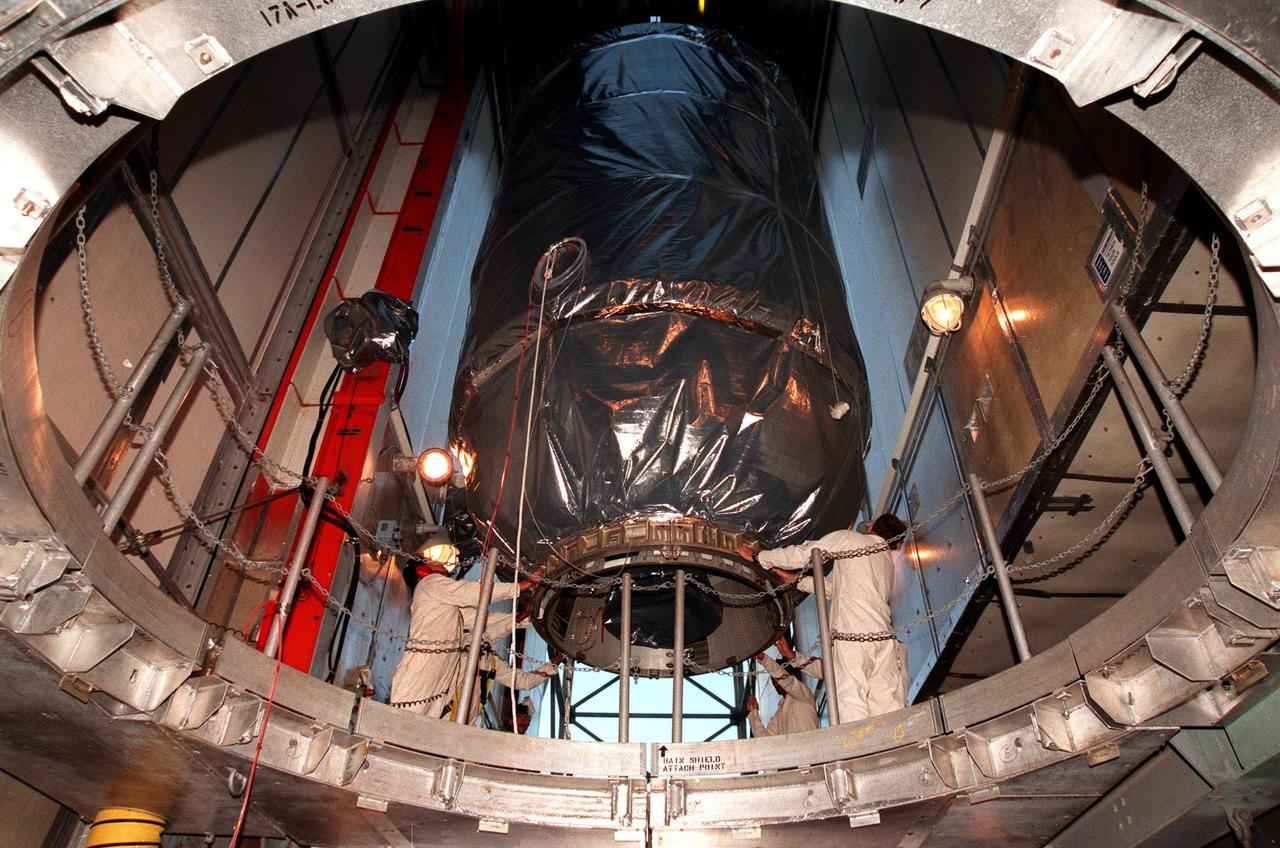KENNEDY SPACE CENTER, FLA. -- Wrapped in a protective covering, the Mars Climate Orbiter with its upper stage booster is lowered in preparation for mating to the second stage of a Boeing Delta II (7425) rocket at Launch Complex 17, Pad A, Cape Canaveral Air Station. Targeted for liftoff on Dec. 10, 1998, the orbiter will be the first spacecraft to be launched in the pair of Mars ’98 missions. After its arrival at the red planet, the Mars Climate Orbiter will be used primarily to support its companion Mars Polar Lander spacecraft, scheduled for launch on Jan. 3, 1999. The orbiter will then monitor the Martian atmosphere and image the planet’s surface on a daily basis for one Martian year, the equivalent of about two Earth years. The spacecraft will observe the appearance and movement of atmospheric dust and water vapor, and characterize seasonal changes on the planet’s surface