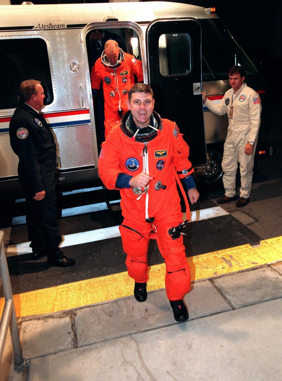 Despite the launch scrub of Space Shuttle Mission STS-88, Commander Robert D. Cabana has a big smile as he returns to the crew quarters in the Operations and Checkout Building. Behind him in the astronaut van is Pilot Frederick W. "Rick" Sturckow. The Space Shuttle Endeavour is slated to make another liftoff attempt on Friday, Dec. 4, for the first U.S. mission dedicated to the assembly of the International Space Station