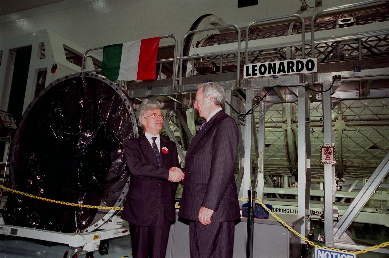 KENNEDY SPACE CENTER, FLA. -- NASA Administrator Daniel S. Goldin (at right) shakes the hand of Sergio De Julio, president of the Italian Space Agency, Agenzia Spaziale Italiana (ASI), during the ceremony transferring the "Leonardo" Multipurpose Logistics Module (MPLM) from ASI to NASA. The event was held in the Space Station Processing Facility beside Leonardo. The MPLM, a reusable logistics carrier, will be the primary delivery system used to resupply and return International Space Station cargo requiring a pressurized environment. Leonardo is the first of three MPLM carriers for the International Space Station. It is scheduled to be launched on Space Shuttle Mission STS-100, targeted for April 2000