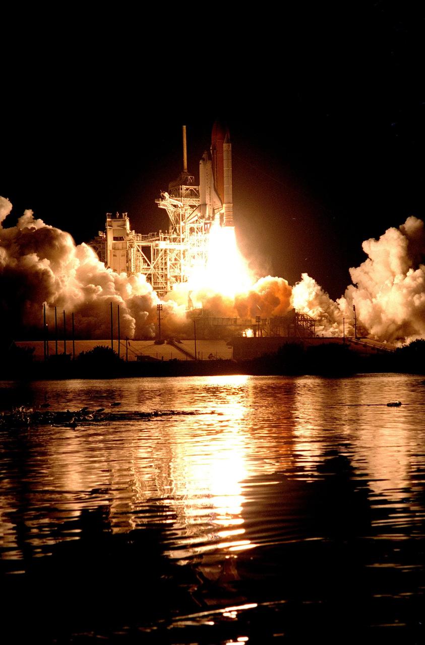 KENNEDY SPACE CENTER, Fla. --  As the Space Shuttle Endeavour lifts off from Launch Pad 39A on Mission STS-88, several fish believed to be mullet (at center left) "launch" themselves out of the water from one of the waterways around the pad. Liftoff of the first U.S. mission dedicated to the assembly of the International Space Station was at 3:35:34 a.m. EST on Dec. 4. During the nearly 12-day mission, the six-member crew will mate in space the first two elements of the International Space Station the already-orbiting Zarya control module with the Unity connecting module carried by Endeavour. Crew members are Commander Robert D. Cabana, Pilot Frederick W. "Rick" Sturckow, and Mission Specialists Nancy J. Currie, Jerry L. Ross, James H. Newman and Sergei Konstantinovich Krikalev, a Russian cosmonaut. This was the second launch attempt for STS-88. The first one on Dec. 3 was scrubbed when launch controllers, following an assessment of a suspect hydraulic system, were unable to resume the countdown clock in time to launch within the remaining launch window