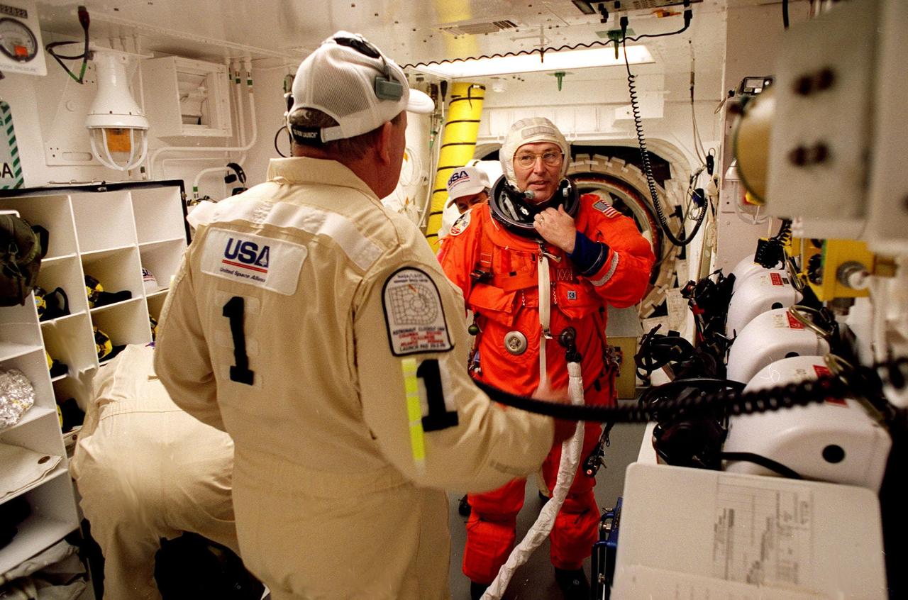 STS-88 Mission Specialist Jerry L. Ross is assisted with his ascent and re-entry flight suit in the white room at Launch Pad 39A before entering Space Shuttle Endeavour for launch. During the nearly 12-day mission, the six-member crew will mate the first two elements of the International Space Station the already-orbiting Zarya control module with the Unity connecting module carried by Endeavour. He is making his sixth spaceflight and is one of two extravehicular activity crew members on this mission