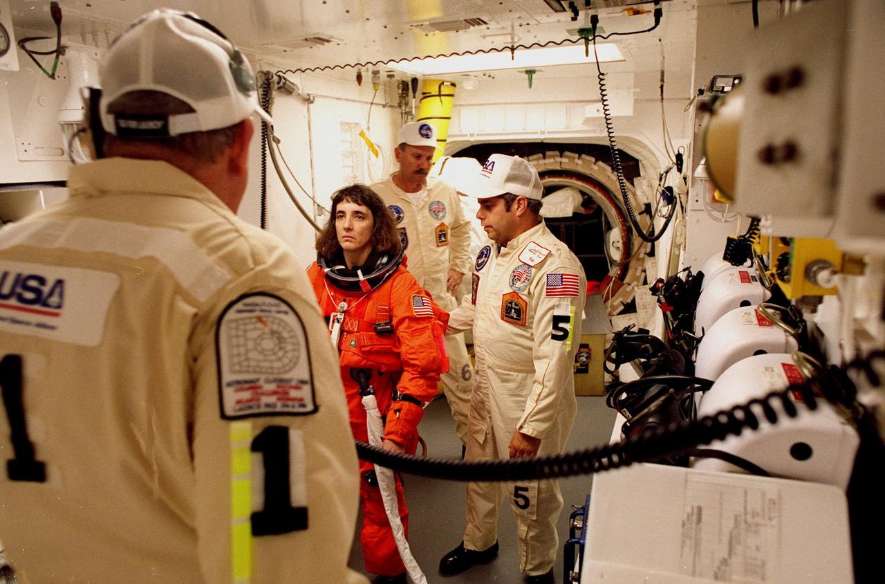 STS-88 Mission Specialist Nancy Jane Currie is assisted with her ascent and re-entry flight suit in the white room at Launch Pad 39A before entering Space Shuttle Endeavour for launch. During the nearly 12-day mission, the six-member crew will mate the first two elements of the International Space Station the already-orbiting Zarya control module with the Unity connecting module carried by Endeavour. She is making her third spaceflight as the crew's flight engineer and prime operator of the Remote Manipulator System, the robotic arm