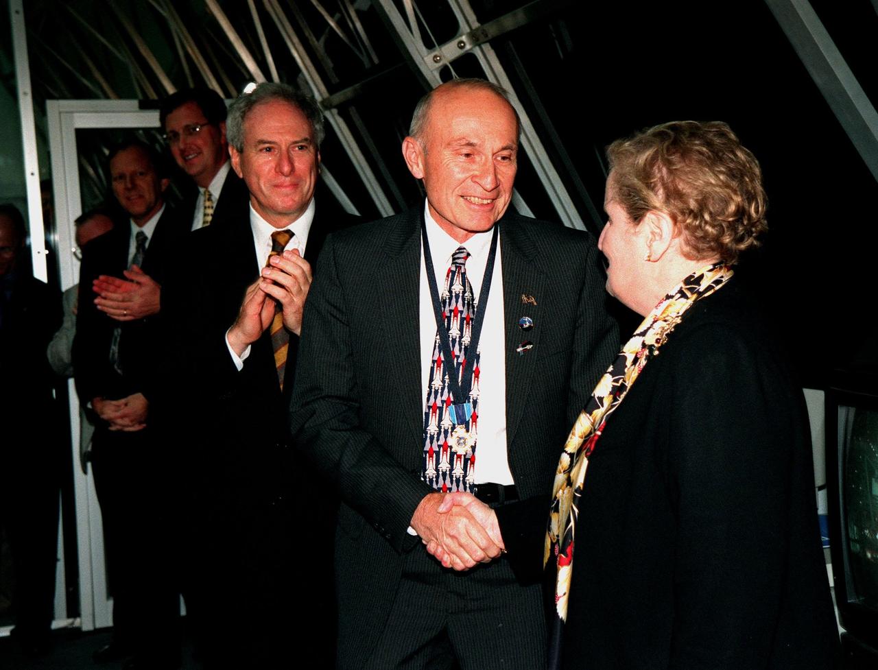In a firing room of the Launch Control Center , KSC Director of Shuttle Operations Robert B. Sieck (center) shakes hands with Secretary of State Madeleine Albright (right) after the successful launch of Space Shuttle Endeavour on mission STS-88 at 3:35:34 a.m. EST. At left is NASA Administrator Daniel Goldin. Sieck is wearing around his neck the Distinguished Service Medal presented him by Goldin following the launch. The medal, the highest honor NASA confers on a government employee, recognizes someone who has personally made a contribution representing substantial and extraordinary progress to the mission of NASA