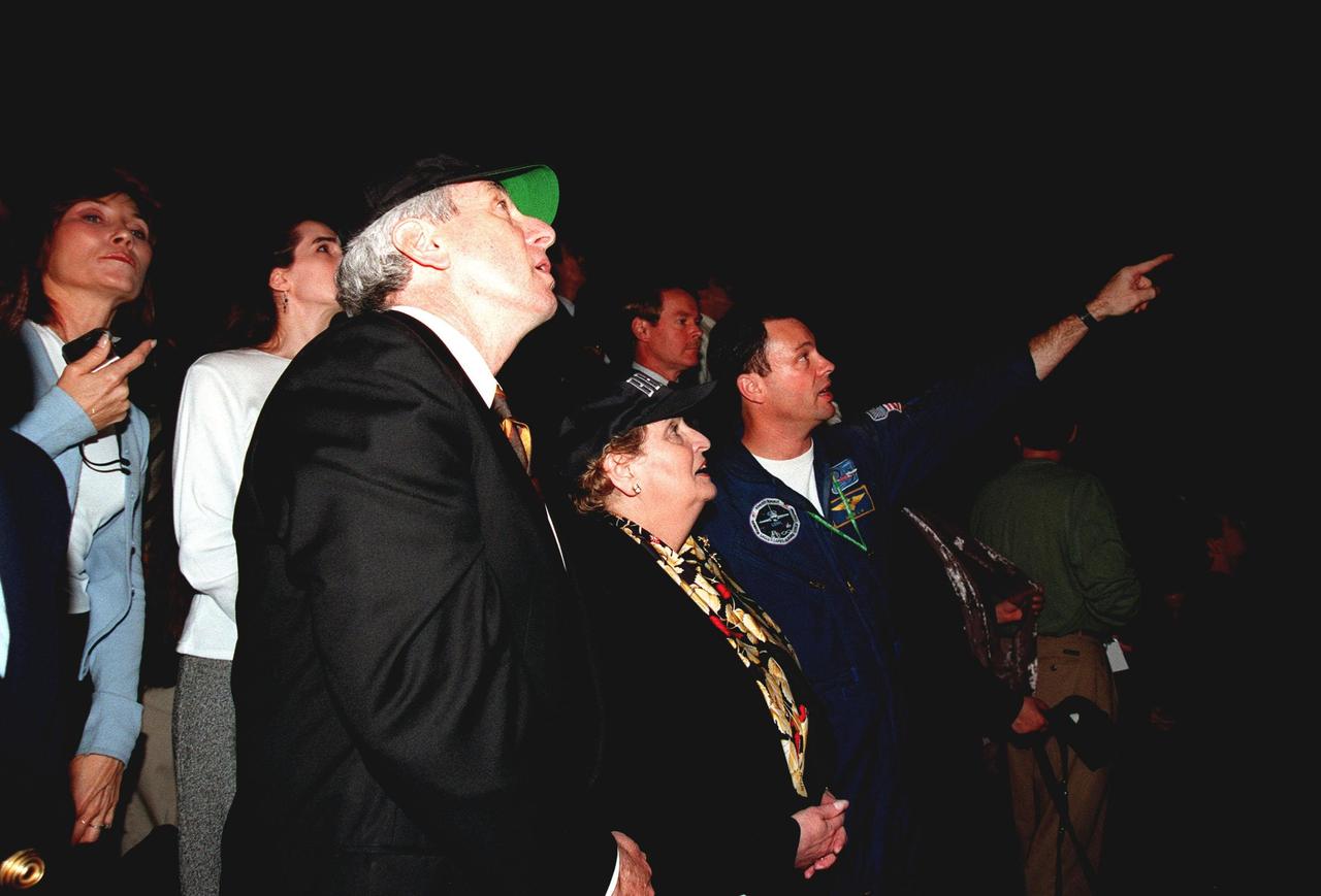 At the Banana Creek Viewing Site, NASA Administrator Daniel Goldin (left), U.S. Secretary of State Madeleine Albright (center) and astronaut Michael Lopez-Alegria watch the launch of STS-88 from Launch Pad 39A at 3:35:34 a.m. EST. STS-88 is the first U.S. mission dedicated to the assembly of the International Space Station (ISS). Lopez-Alegria is part of the STS-92 crew that is assigned to the fourth ISS assembly flight scheduled for launch on Oct. 28, 1999, aboard Discovery