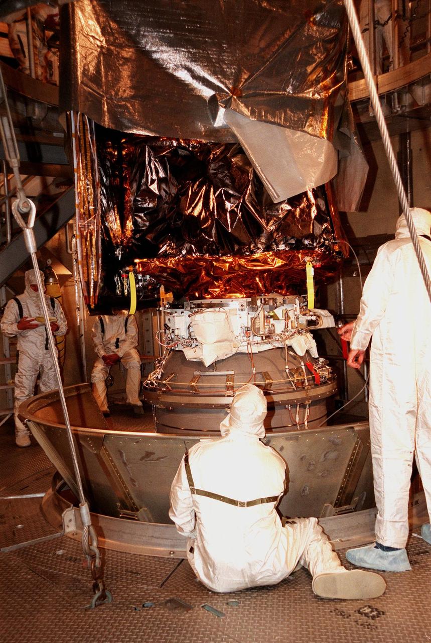 KENNEDY SPACE CENTER, FLA. -- At Launch Complex 17A, Cape Canaveral Air Station, workers remove the canister surrounding the Mars Climate Orbiter. Targeted for liftoff on Dec. 10, 1998, aboard a Boeing Delta II (7425) rocket, the orbiter will be the first spacecraft to be launched in the pair of Mars '98 missions. After its arrival at the red planet, the Mars Climate Orbiter will be used primarily to support its companion Mars Polar Lander spacecraft, scheduled for launch on Jan. 3, 1999. The orbiter will then monitor the Martian atmosphere and image the planet's surface on a daily basis for one Martian year, the equivalent of about two Earth years. The spacecraft will observe the appearance and movement of atmospheric dust and water vapor, and characterize seasonal changes on the planet's surface