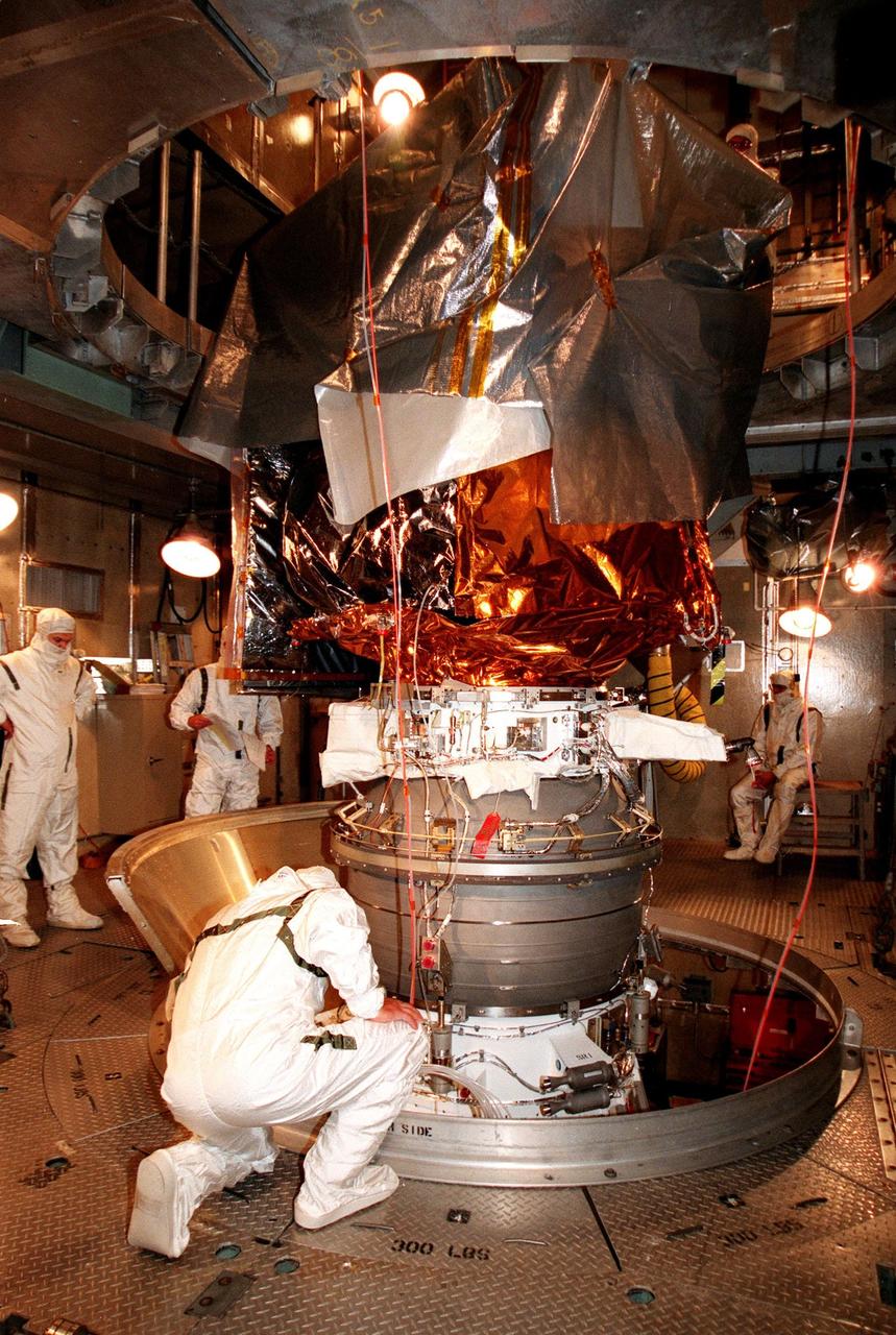 KENNEDY SPACE CENTER, FLA. -- At Launch Complex 17A, Cape Canaveral Air Station, workers get ready to remove the last piece of the canister surrounding the Mars Climate Orbiter. Targeted for liftoff on Dec. 10, 1998, aboard a Boeing Delta II (7425) rocket, the orbiter will be the first spacecraft to be launched in the pair of Mars '98 missions. After its arrival at the red planet, the Mars Climate Orbiter will be used primarily to support its companion Mars Polar Lander spacecraft, scheduled for launch on Jan. 3, 1999. The orbiter will then monitor the Martian atmosphere and image the planet's surface on a daily basis for one Martian year, the equivalent of about two Earth years. The spacecraft will observe the appearance and movement of atmospheric dust and water vapor, and characterize seasonal changes on the planet's surface