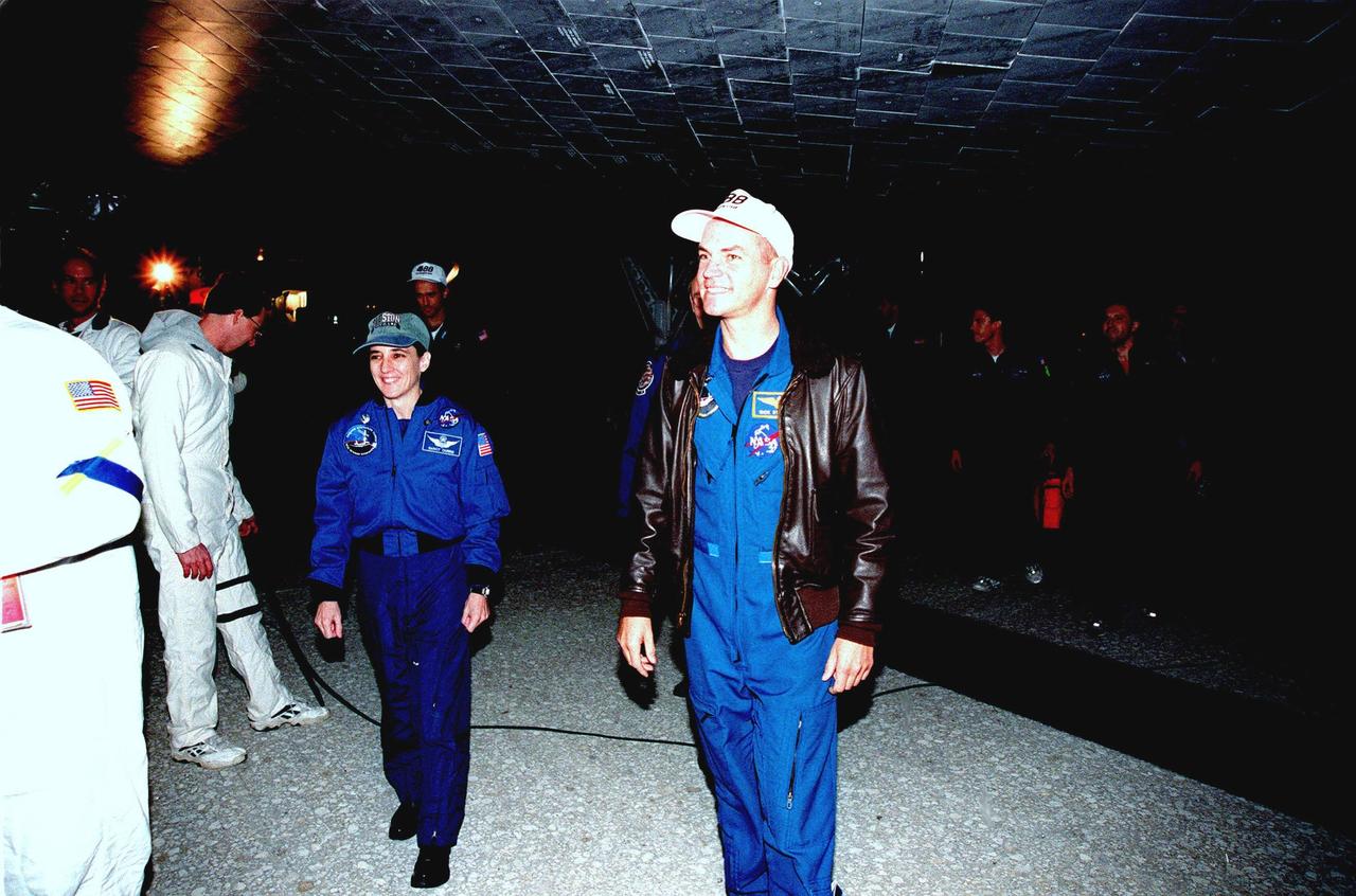 After an end-of-mission landing on Runway 15 of KSC's Shuttle Landing Facility aboard orbiter Endeavour at 10:53:29 p.m. EST, STS-88 Mission Specialist Nancy J. Currie (left) and Pilot Frederick W. "Rick" Sturckow (right) walk under the orbiter to greet well-wishers. Also on board were Commander Robert D. Cabana and Mission Specialists Jerry L. Ross, James H. Newman and Sergei Konstantinovich Krikalev, a Russian cosmonaut. On the 4.6-million-mile, nearly 12-day flawless mission, Endeavour carried the U.S.-built Unity connecting module to begin construction of the International Space Station. The crew successfully mated Unity with the Russian-built Zarya control module during three space walks. With this mission, Ross completed seven space walks totaling 44 hours and 9 minutes, more than any other American space walker. Newman moved into third place for U.S. space walks with a total of 28 hours and 27 minutes on four excursions